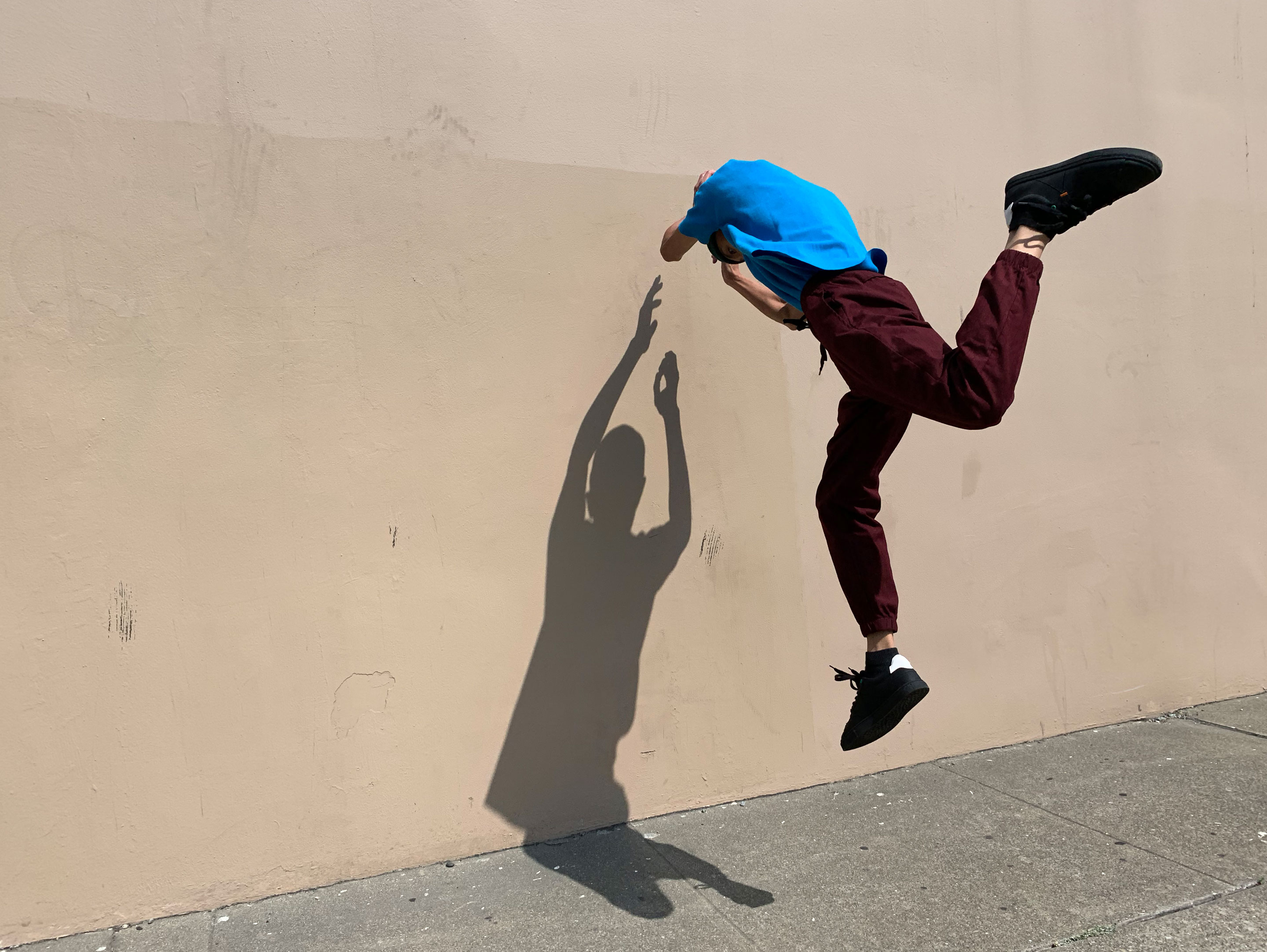 HDR image of a man jumping with his shadow casting on the wall