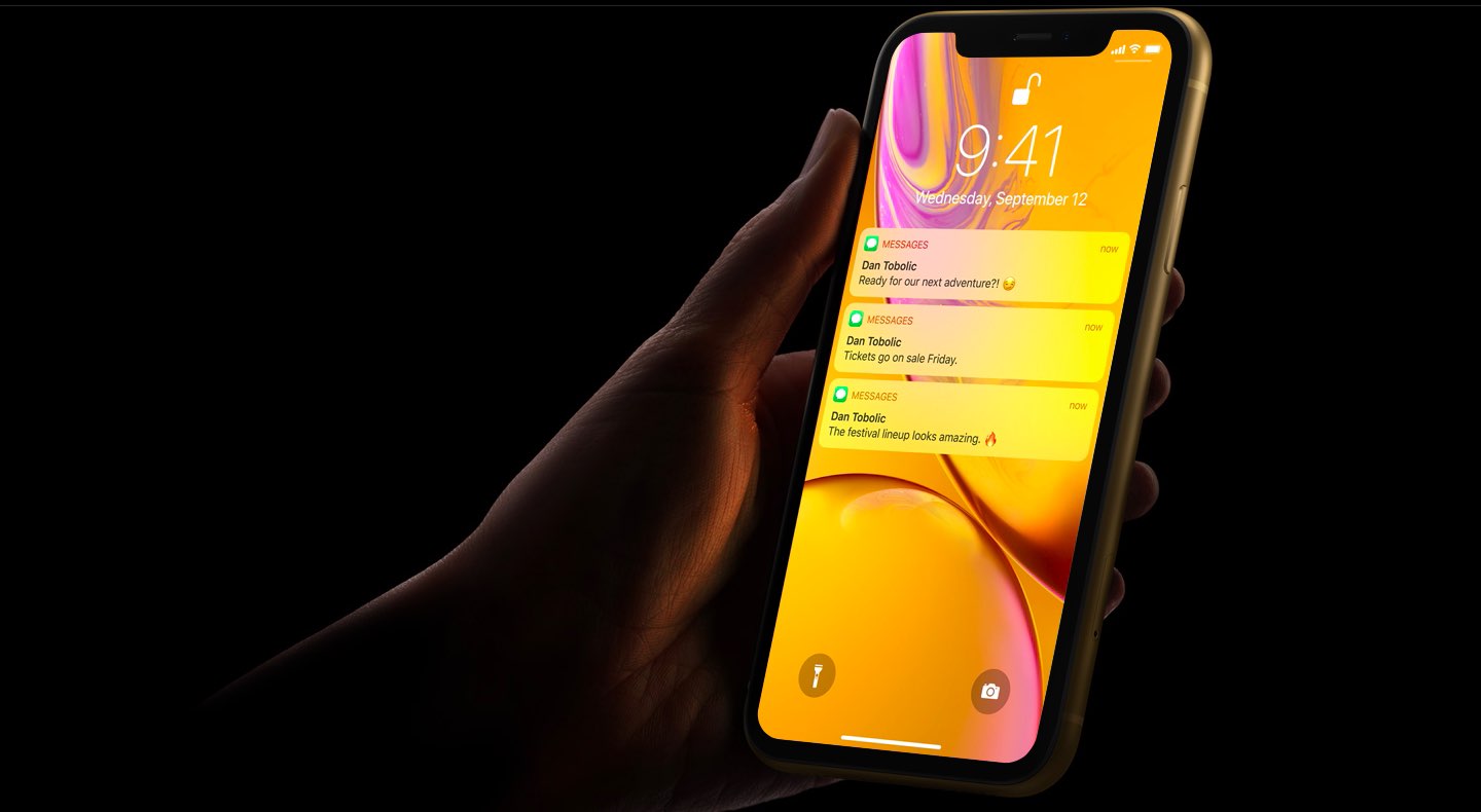 Marketing image showing an iPhone XR in a woman's hands, with the lock screen notifications unlocked with Face ID
