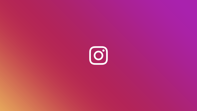 A white Instagram logo set against a colorful gradient background 