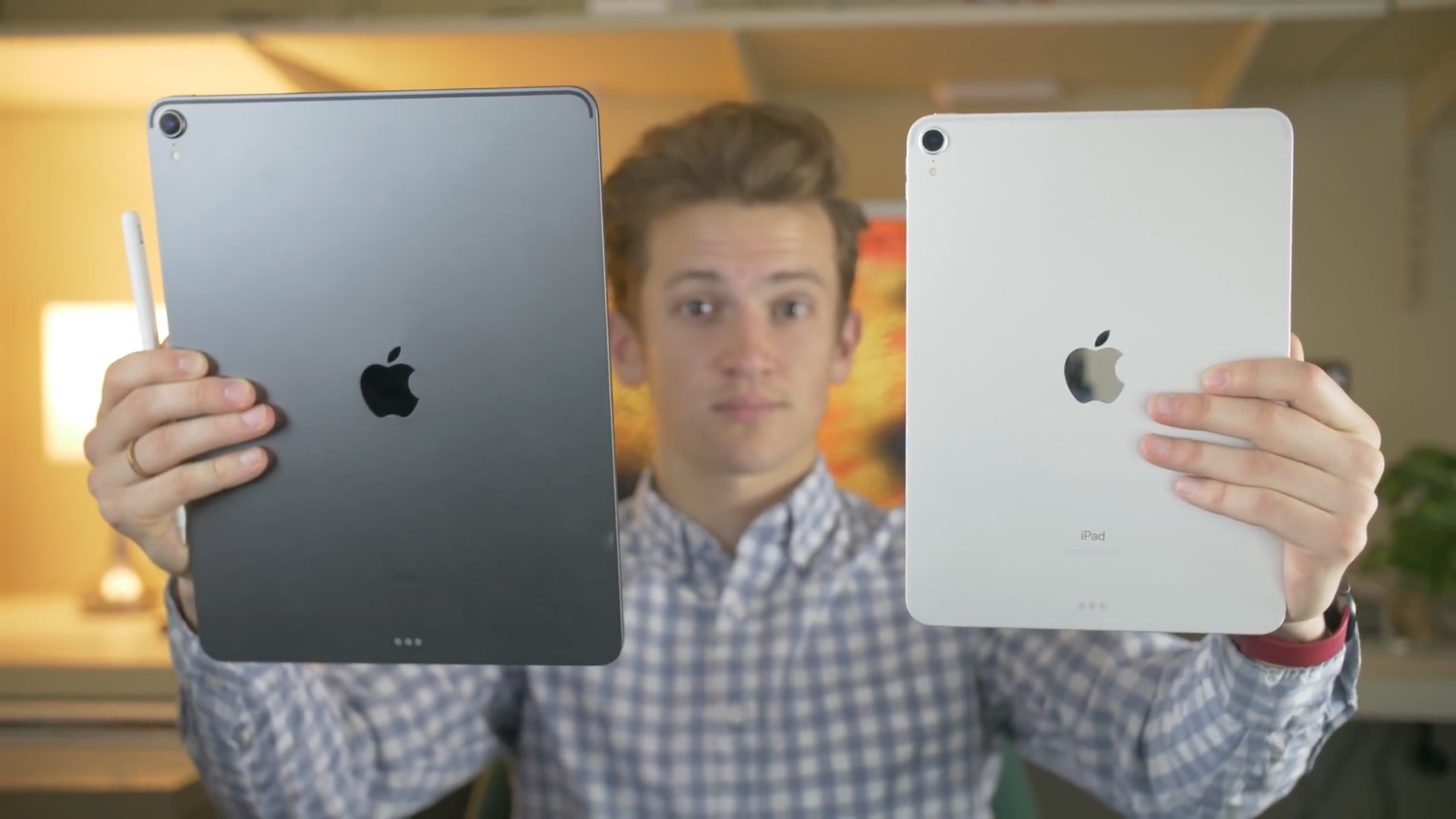 Photo showing a person holding two iPad Pro models in their hands, the bigger 12.9-inch model in the left hand and the smaller 11-inch one in their right hand