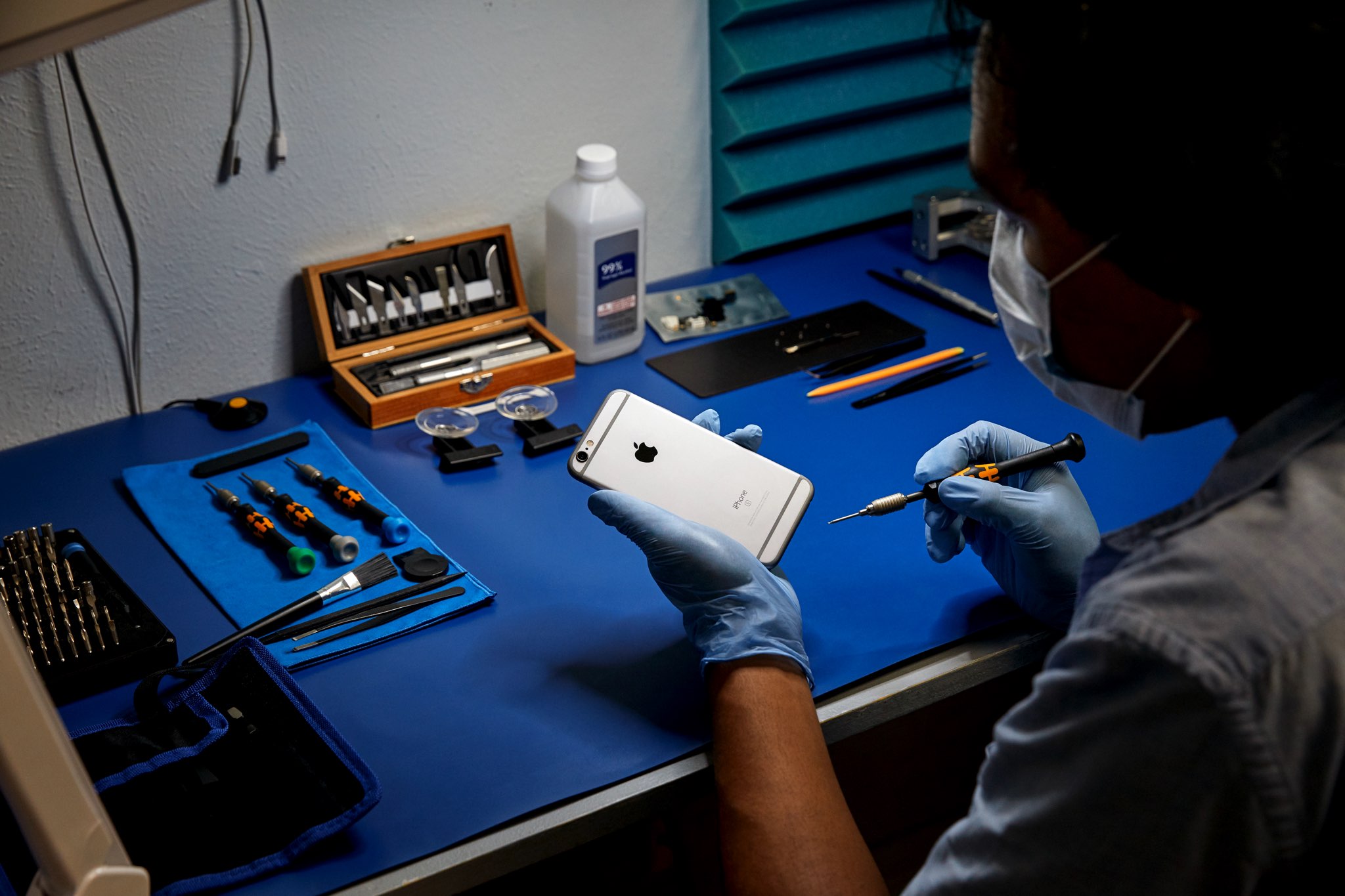 This marketing image from Apple shows an independent repair provider using genuine parts to service an iPhone