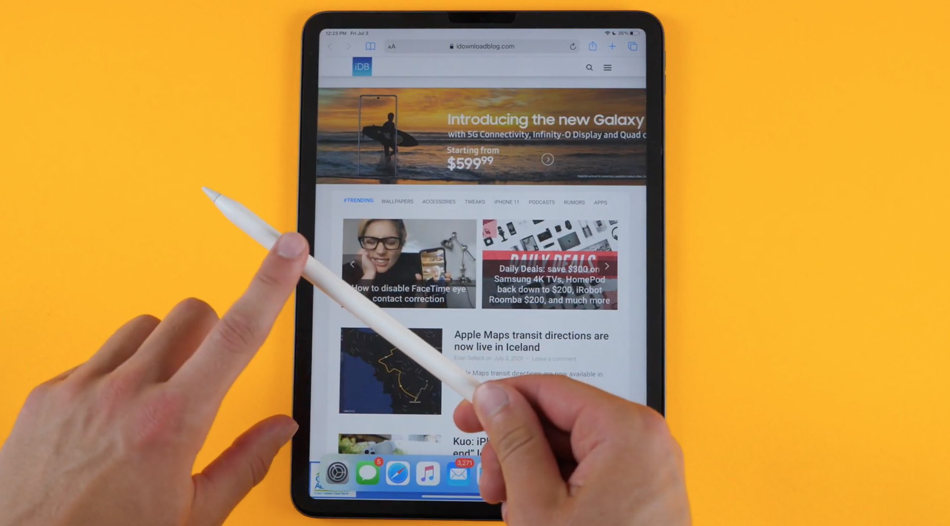 A photo showing a hand holding an Apple Pencil above an iPad Air