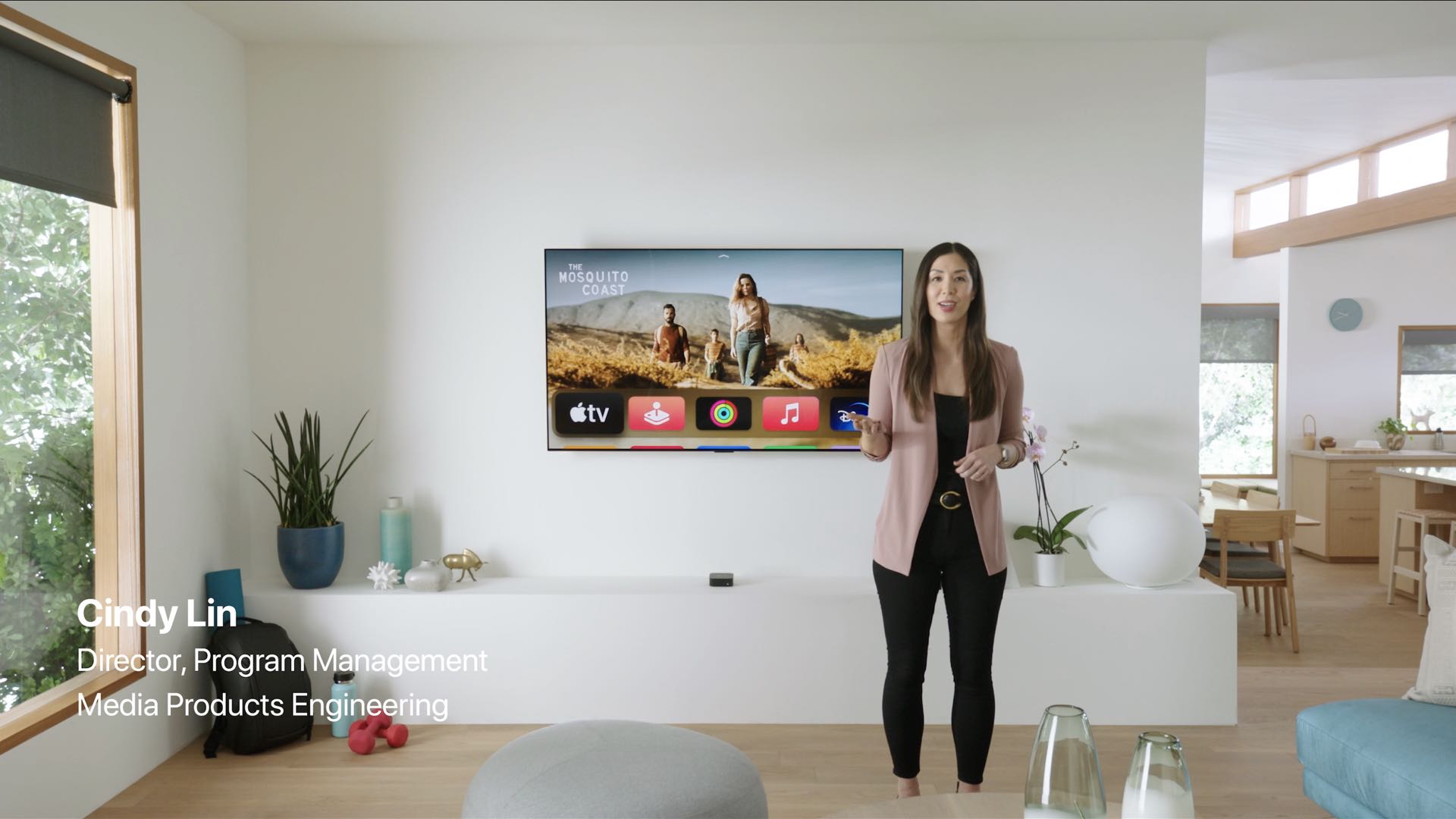 A still image from the April 2021 Apple event video in which executive Cindy Lin discusses the Apple TV 4K while standing in front of a TV in a living room set