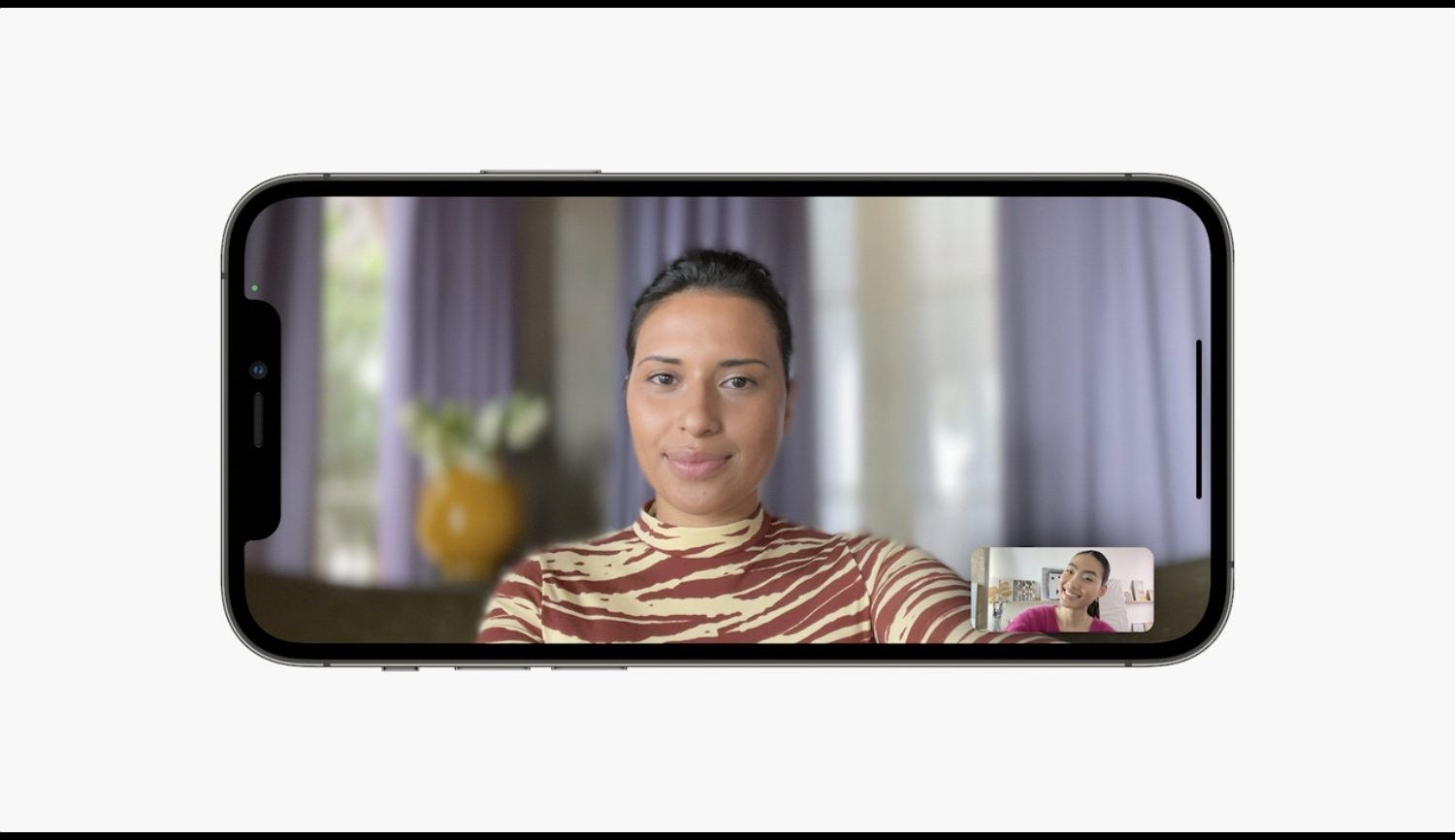 An iPhone showing a woman on iPhone screen during a video call with her background blurred