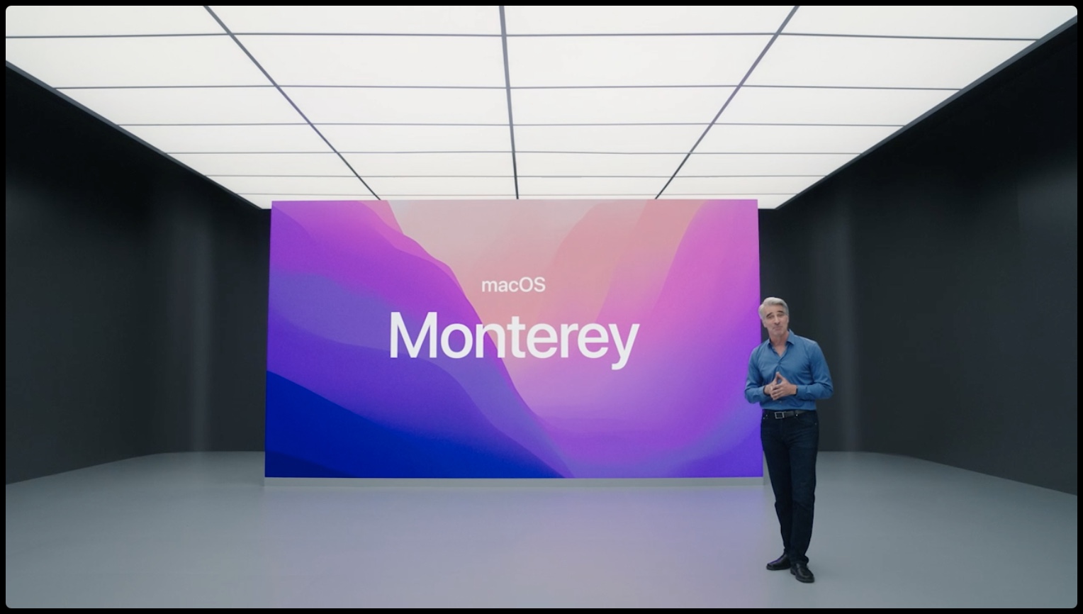 A still from Apple's presentation with Craig Federighi standing in front of a slide with the text "macOS Monterey"