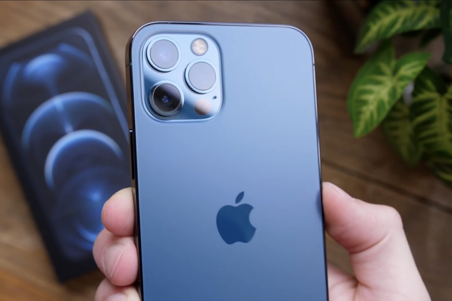 A hand holding an iPhone 12 Pro Max with the rear camera array shown