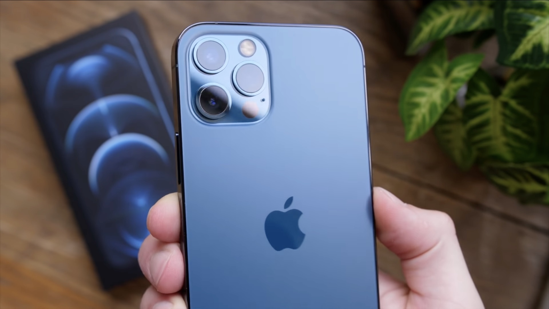 A hand holding an iPhone 12 Pro Max with the rear camera array shown