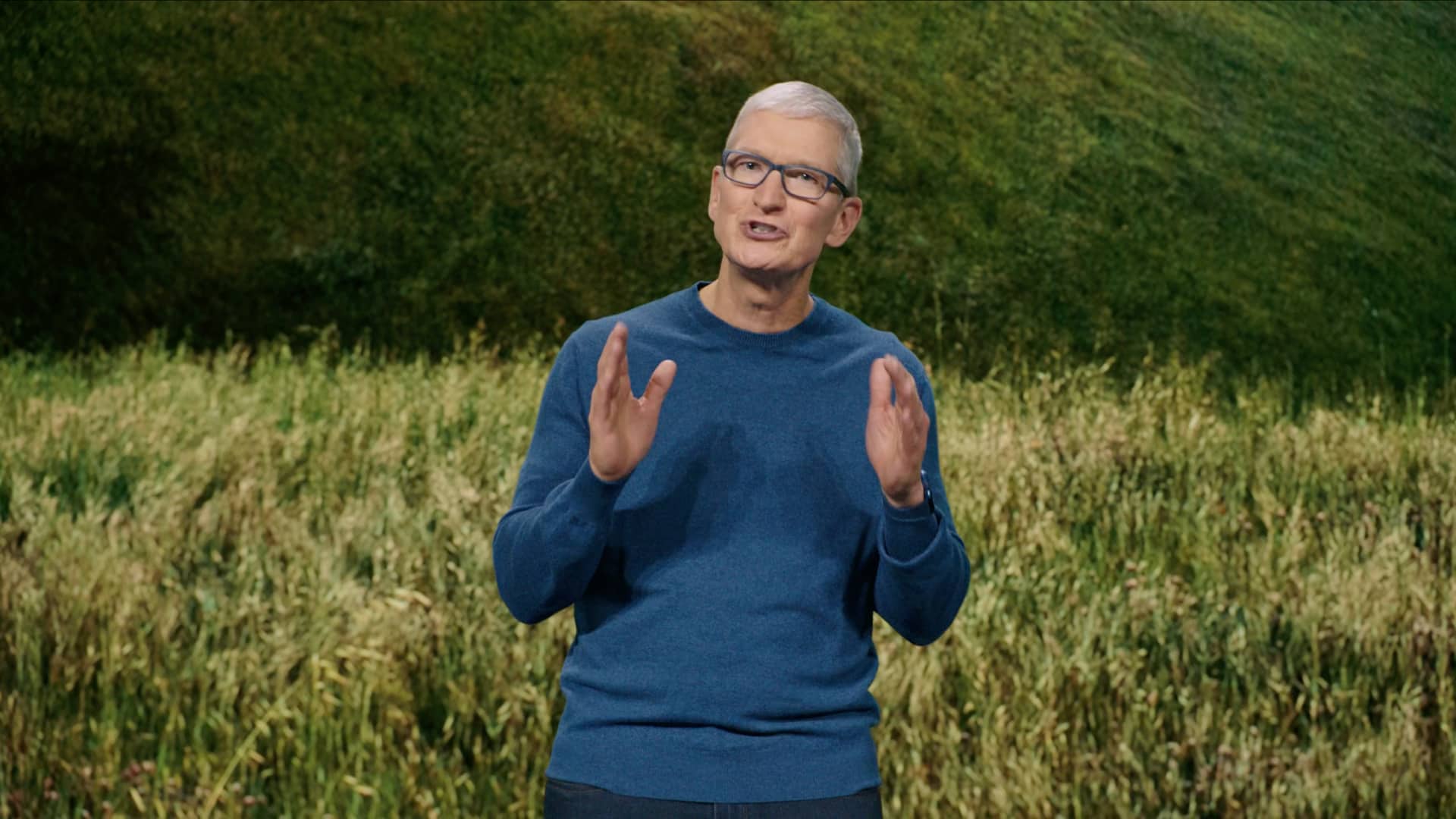 A still image taken from Apple's September 2021 “California Streaming” event video which shows CEO Tim Cook standing on stage and talking enthusiastically while gesturing with his hands