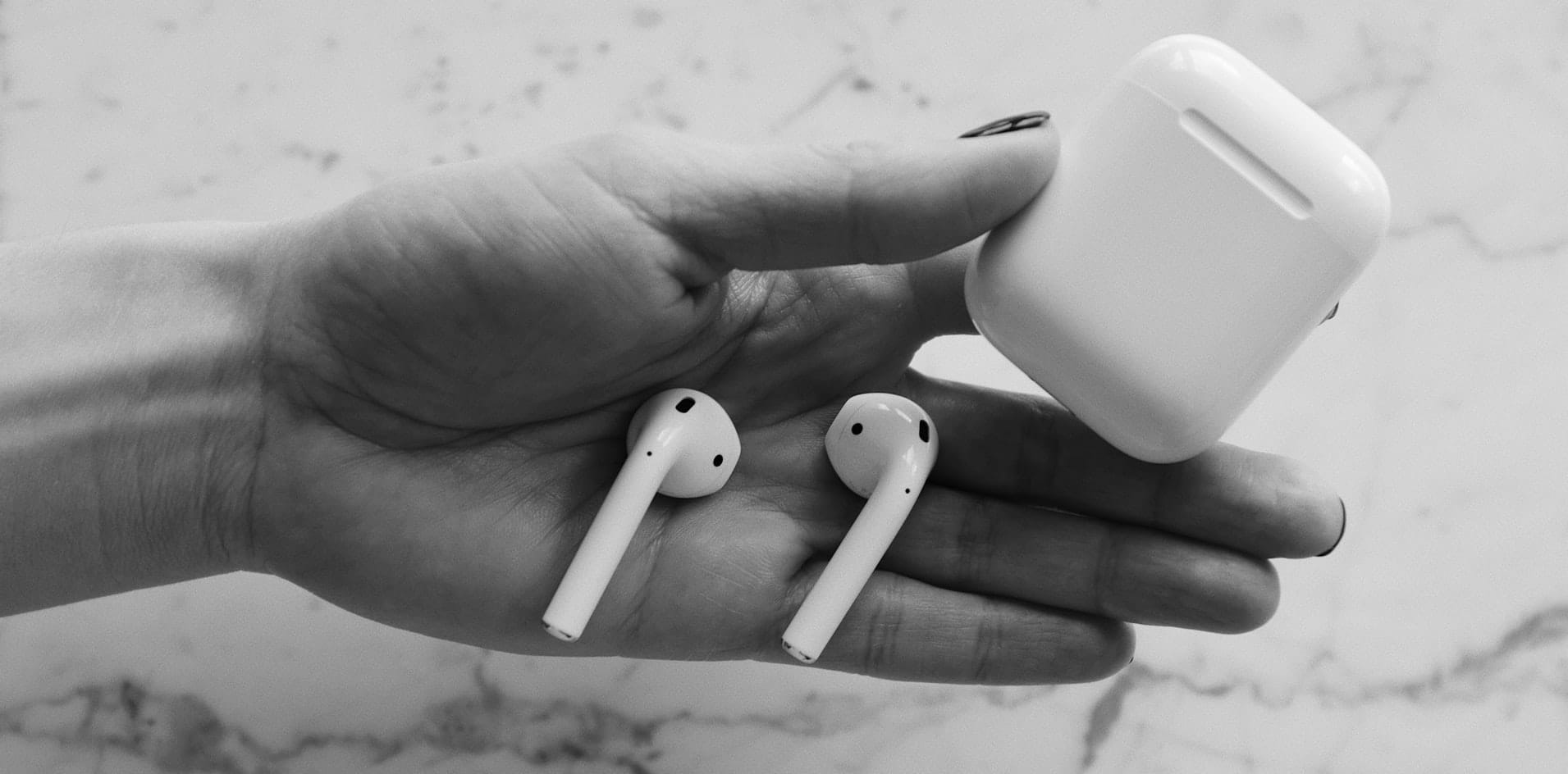 AirPods and its case on palm