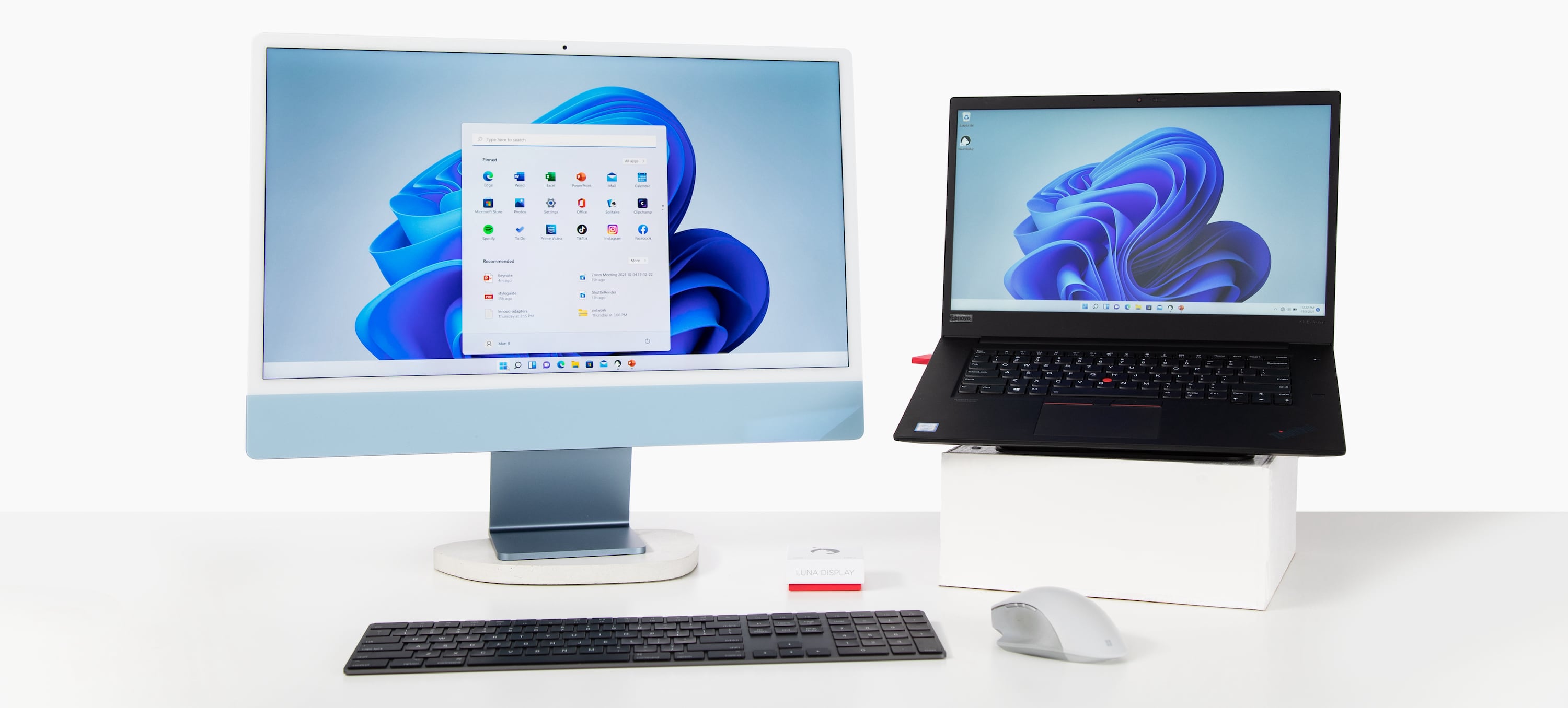 Marketing image showing an iMac acting as a secondary wireless display for Lenovo's Windows PC laptop via the Luna Display USB-C dongle