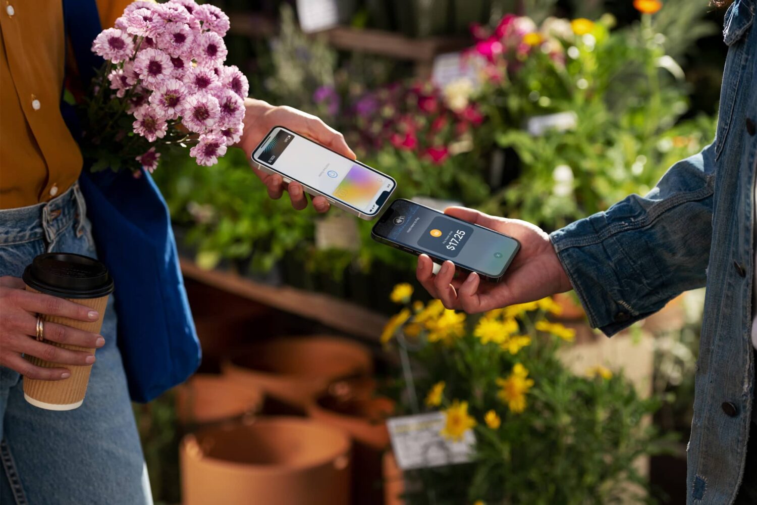 Apple's marketing image showing two young women tapping the top of their iPhones to use the Tap to Pay NFC contactless payments feature in Apple Pay