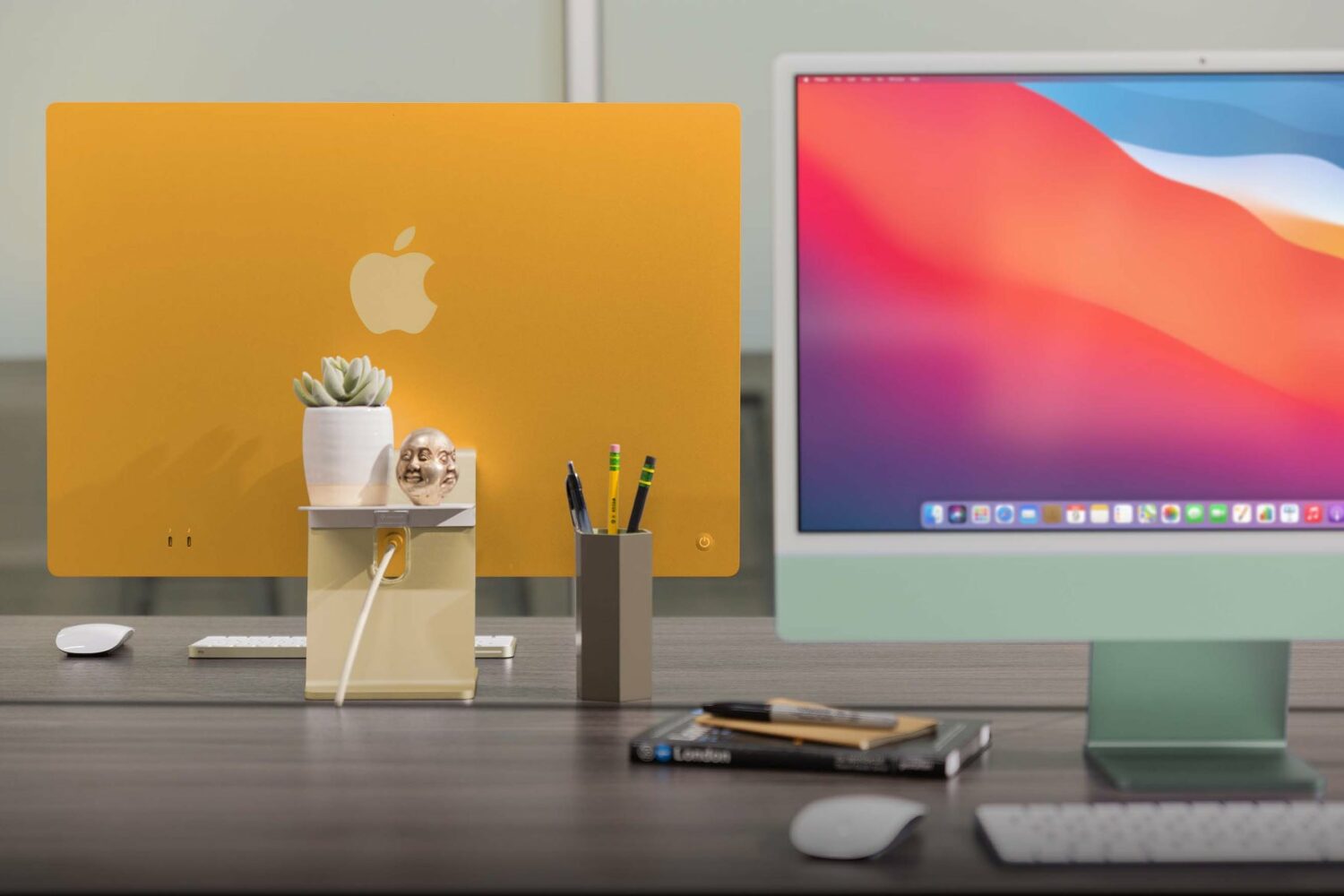 A promotional image from Twelve South showcasing its BackPack matte white aluminum shelf attached to the back of an orange 24-inch M1 iMac