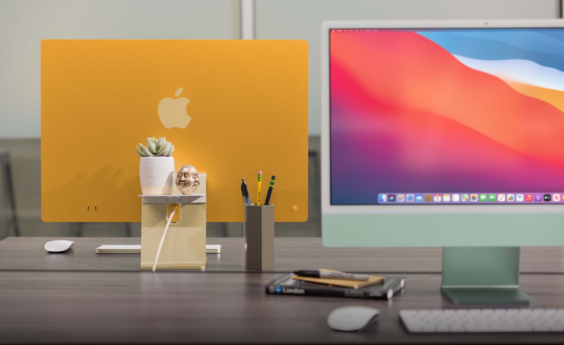 A promotional image from Twelve South showcasing its BackPack matte white aluminum shelf attached to the back of an orange 24-inch M1 iMac