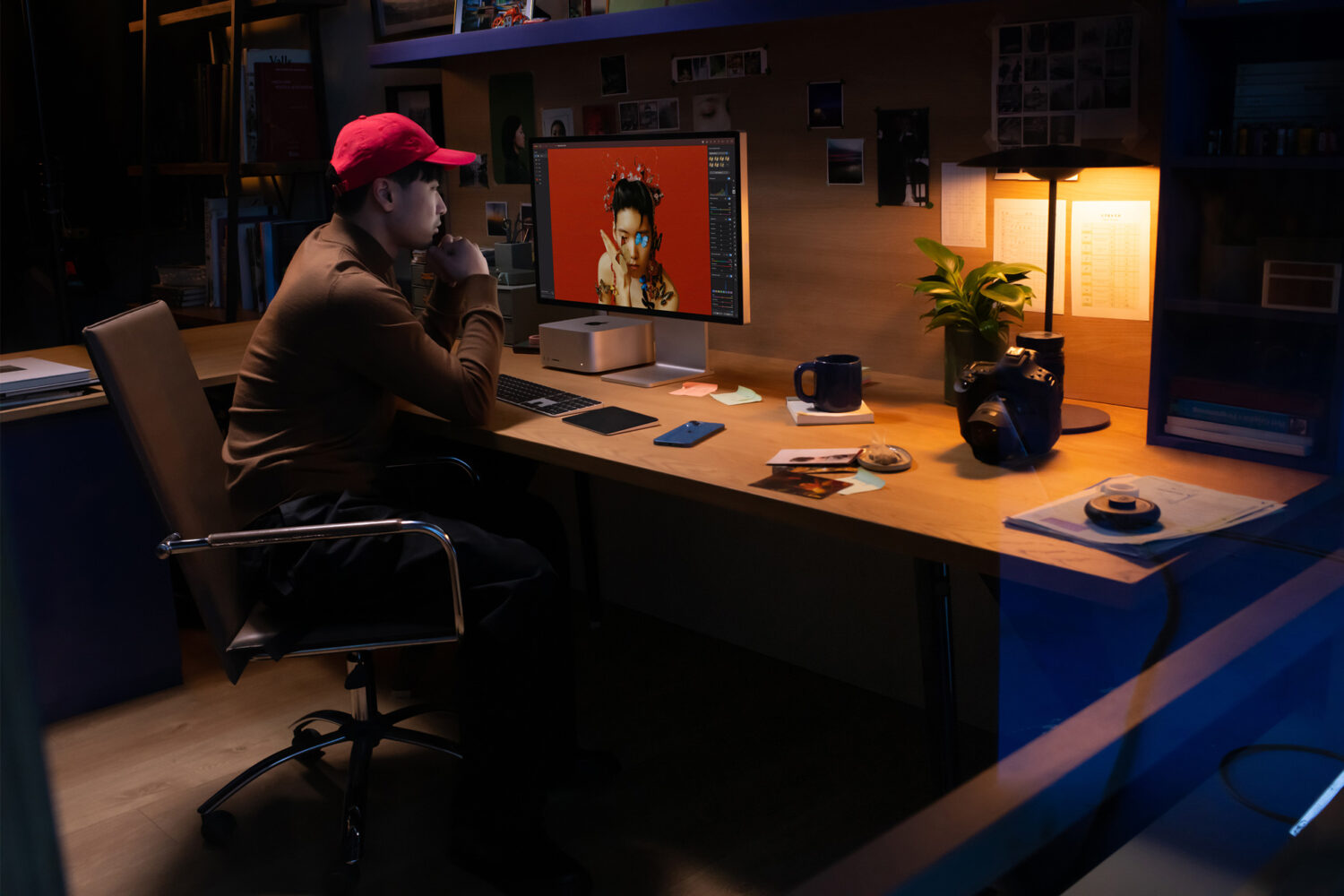 Apple's marketing image showing a creative professional sitting at their desk and using a Mac Studio computer connected to a Studio Display