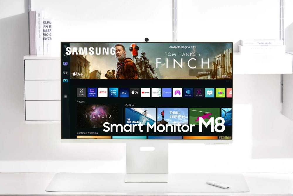Marketing image showcasing Samsung's Smart Monitor M8 external display featuring built-in AirPlay and Apple's TV app