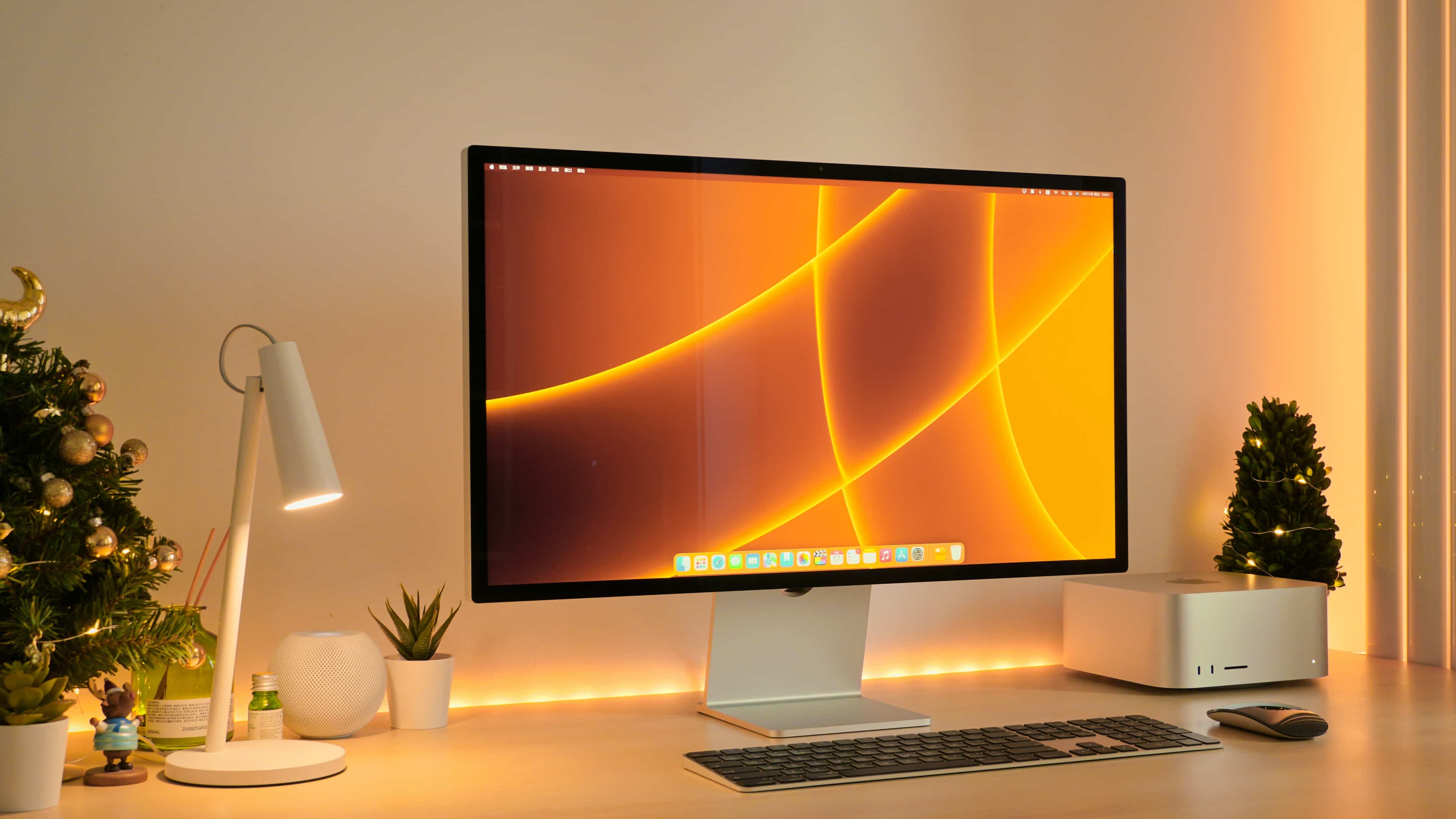 Apple's Studio Display and Mac Studio are featured sitting on a work desk in this lifestyle photograph