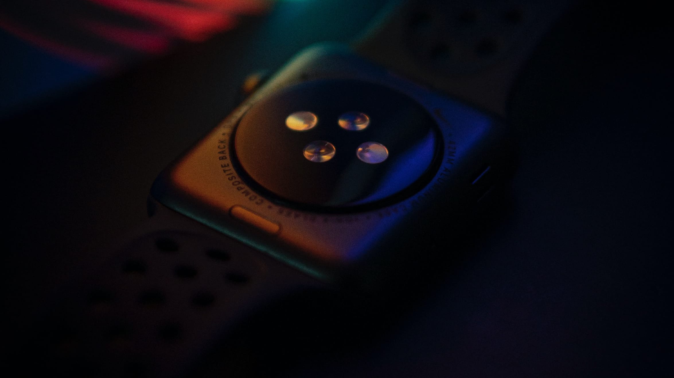 Apple Watch Series 7 laid facedown, with the optical heart rate sensor on its back crystal exposed