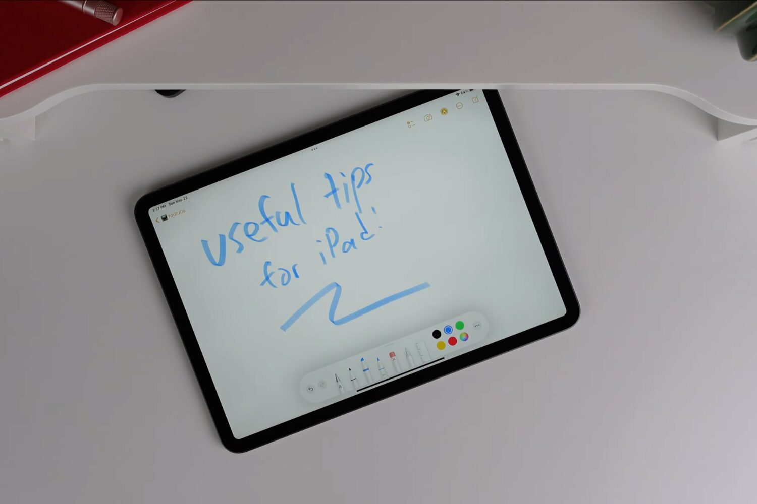 In this photo, Apple's iPad is seen laid flat on its back on a table. A handwritten note saying "Useful tips for iPad!" is shown on the screen.