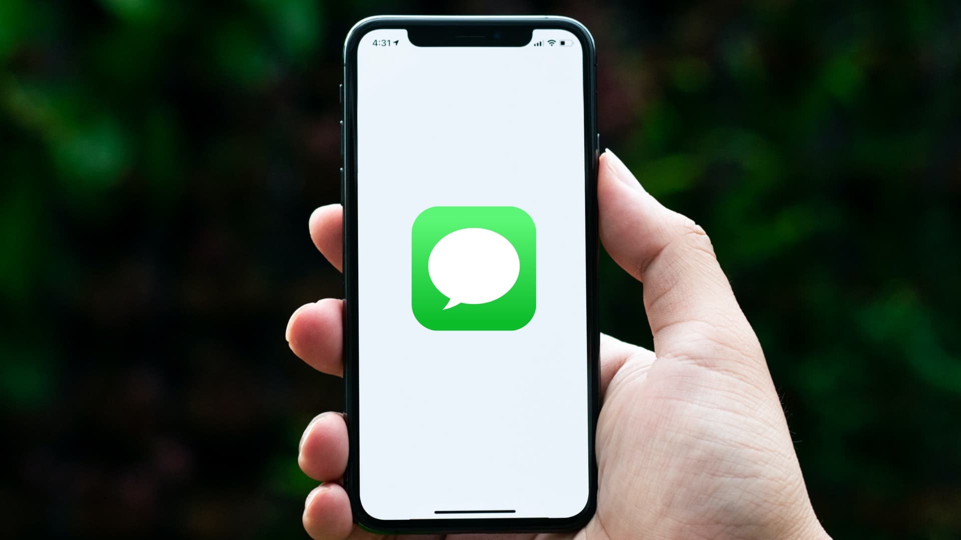 Holding iPhone with Messages app icon on the screen