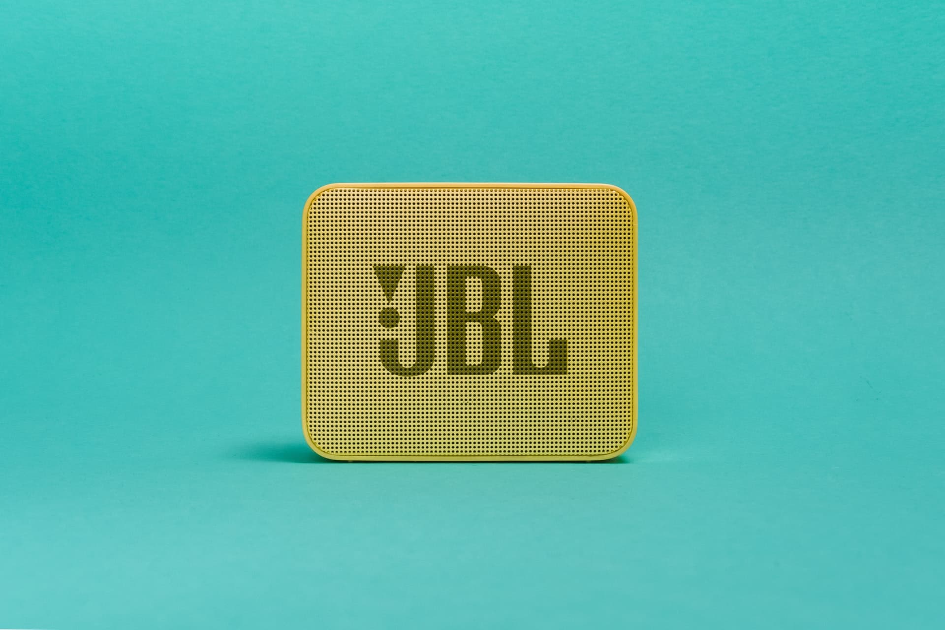 JBL Bluetooth speaker on a sea green background