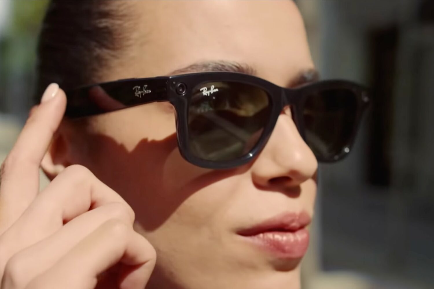 A young woman is wearing a pair of Ray-Ban Stories smart glasses, realized in partnership with Meta (formerly Facebook), in this promotional image