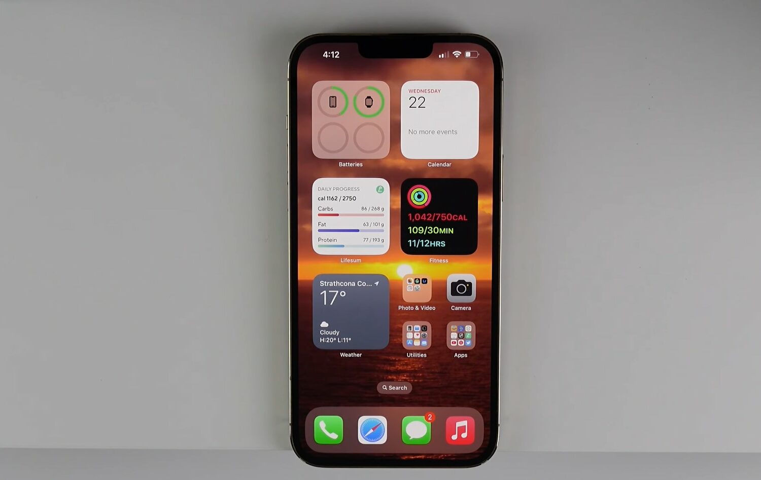 An iPhone with a bunch of widgets, apps and folders displayed on the home screen