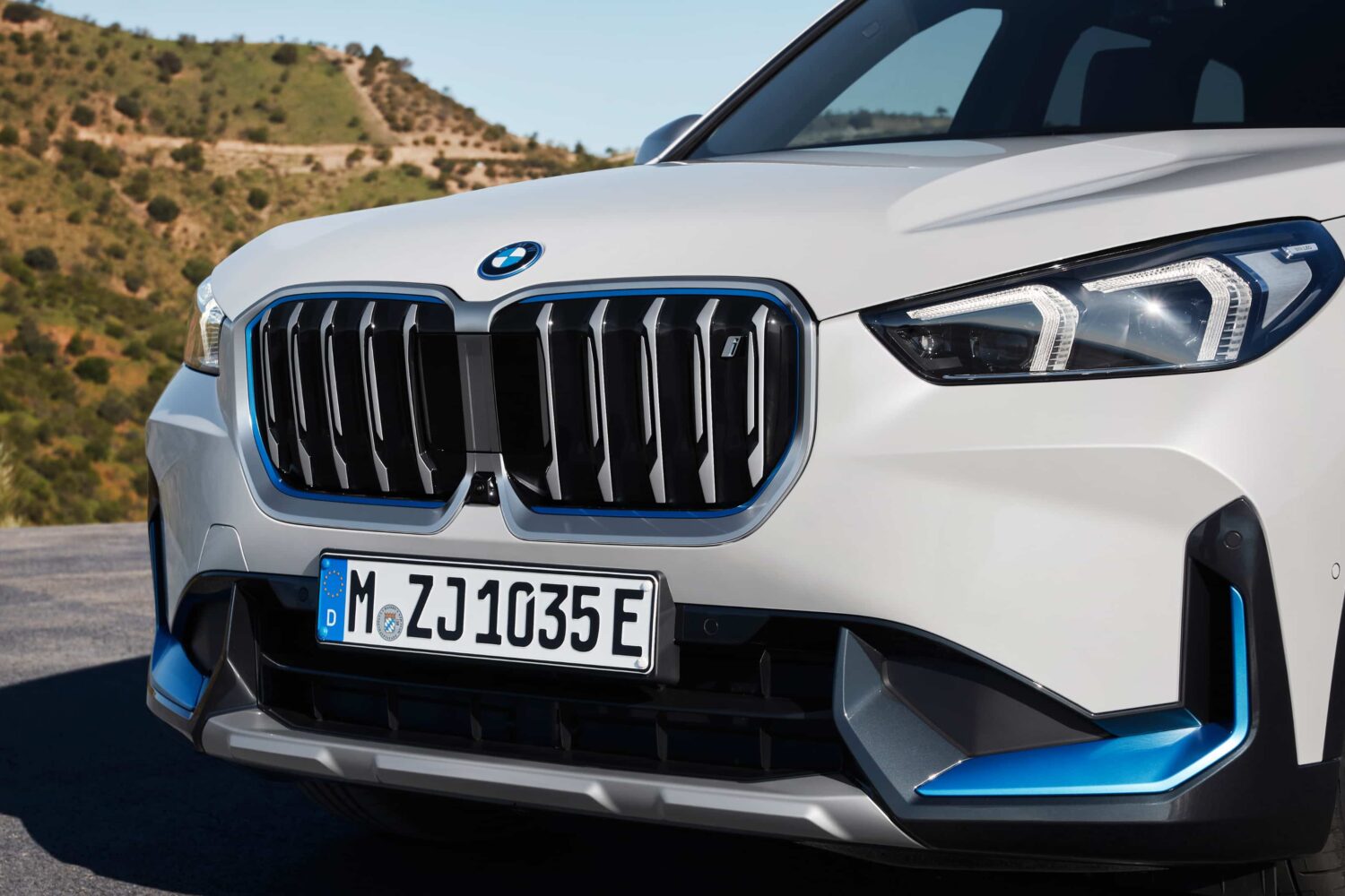 The front side of the BMW iX1, the company's first all-electric SUV, is showcased on this marketing photo