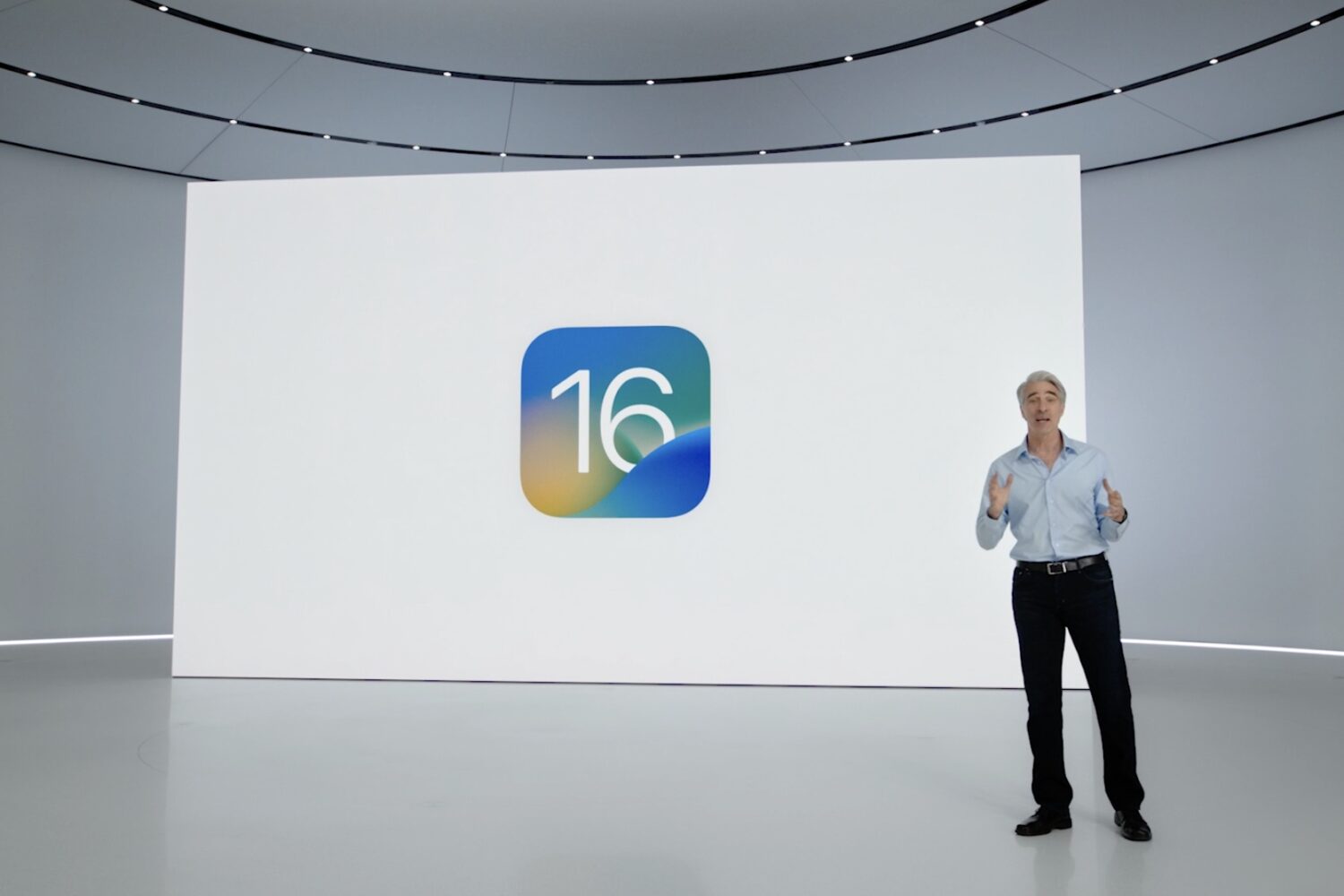 A scene from the June 6 WWDC 2022 keynote, with Apple's software chief Craig Federighi standing in front of a slide showcasing the iOS 16 icon