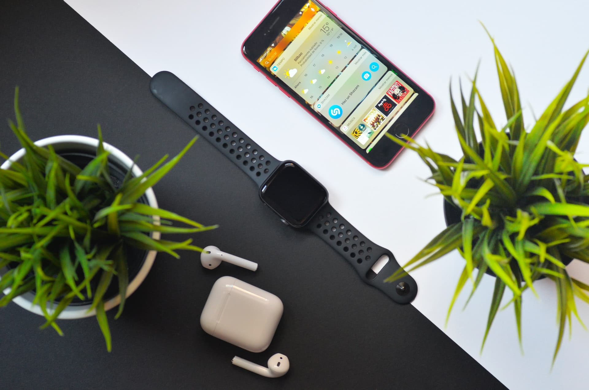 Apple Watch kept on a table with an iPhone and AirPods nearby