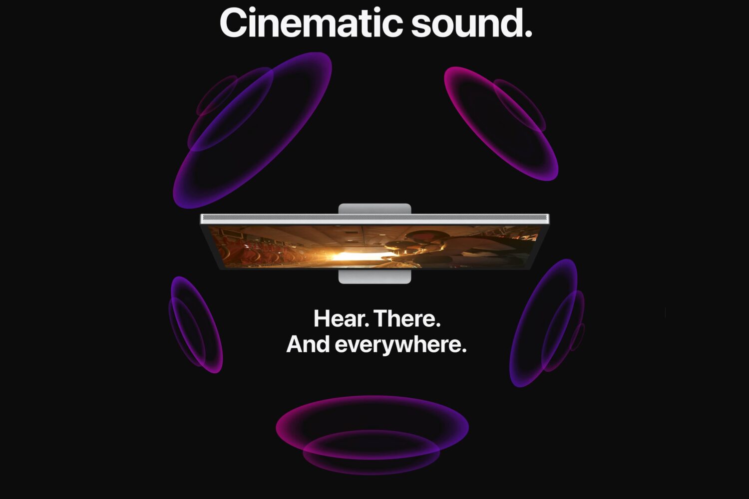 Top-down view of the Studio Display and the tagline "Hear. There. And everywhere" promoting spatial sound support