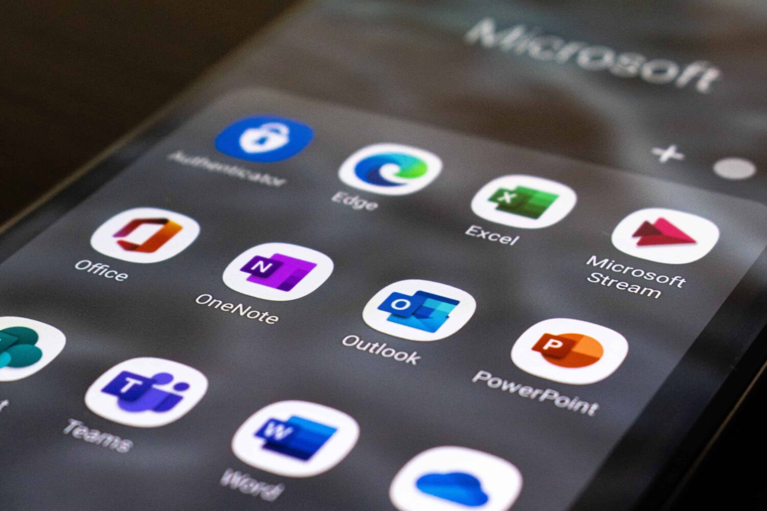 An iPhone home screen showing a Microsoft folder full of icons of Office productivity apps
