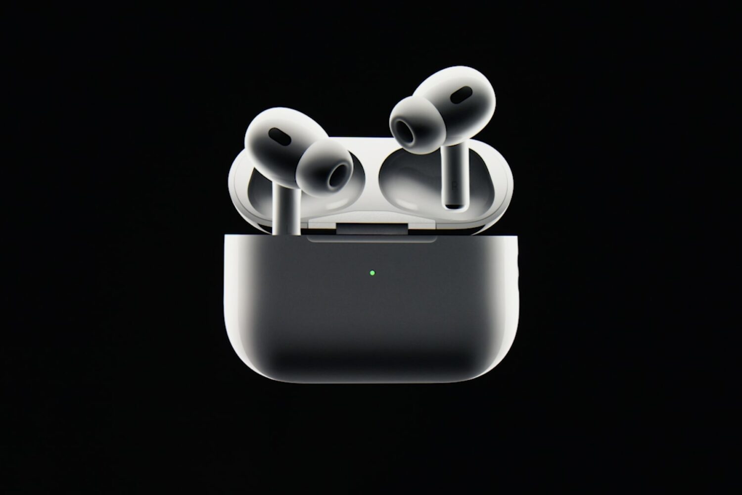 AirPods Pro in their charging case with the lid open, set against a solid black background