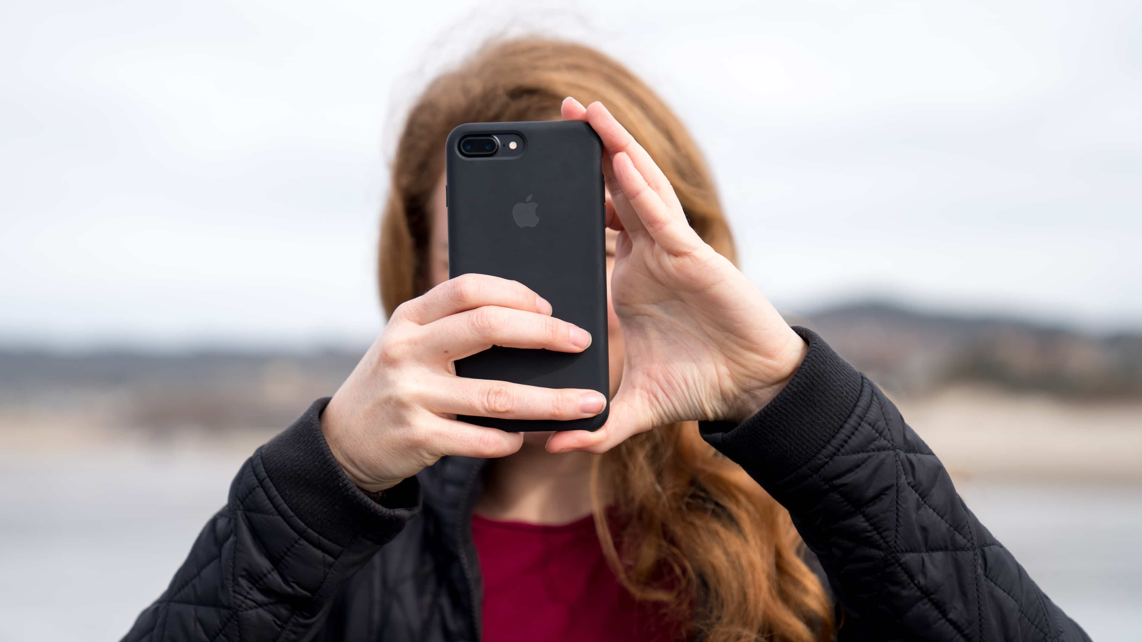 Woman using her iPhone 7 Plus to take Portrait Mode photo