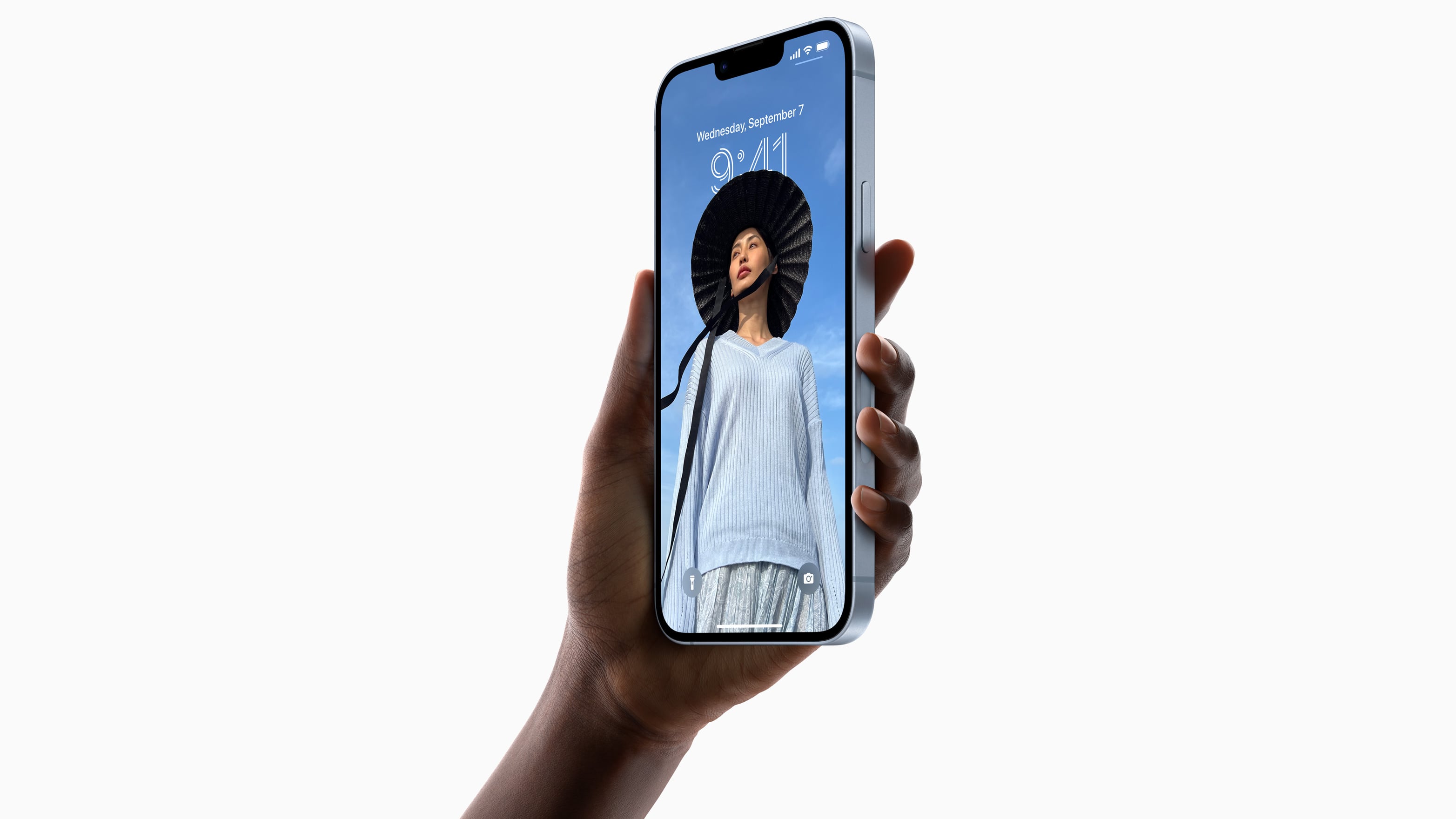 Blue iPhone 14 Plus held in hand, with the lock screen active