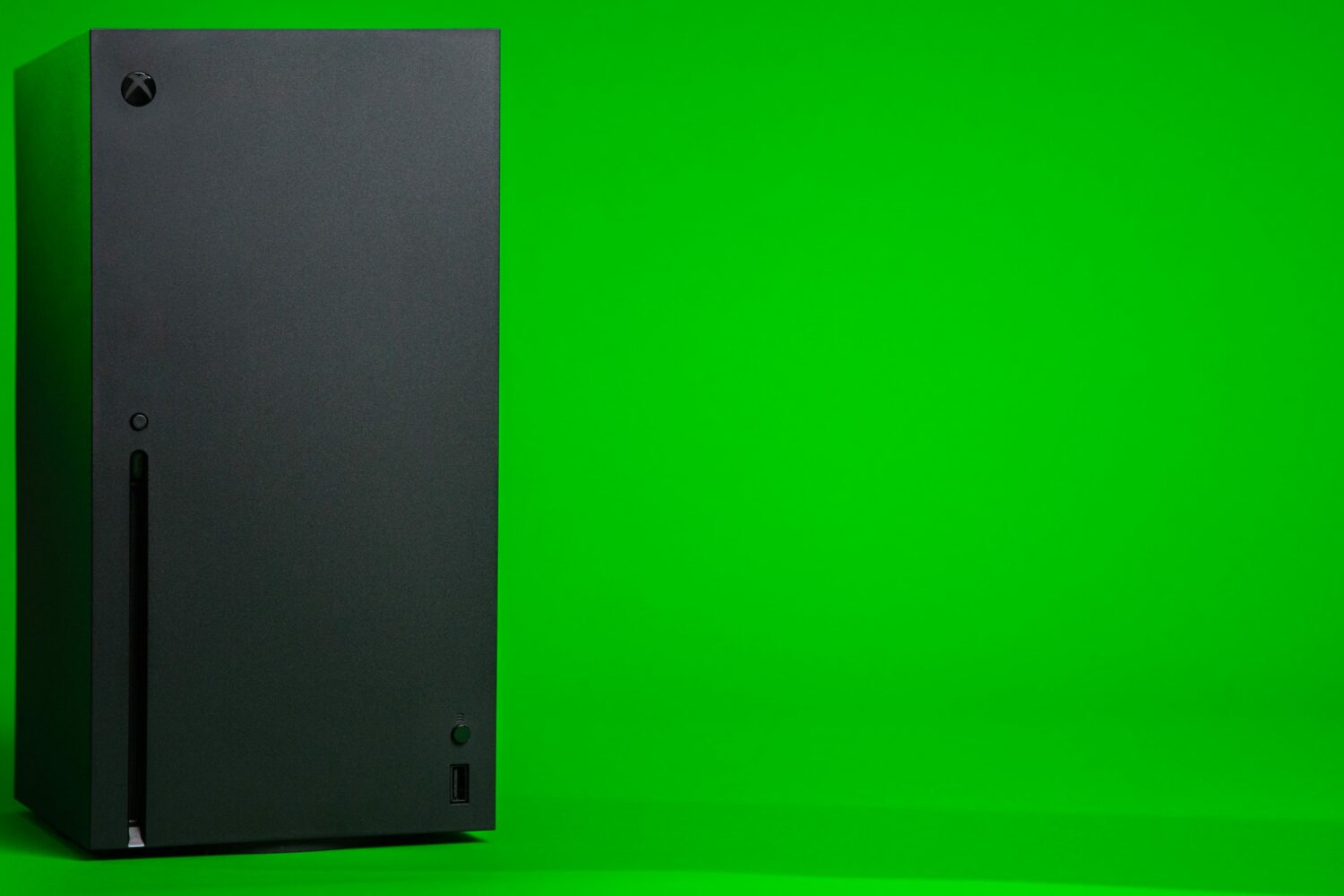 Microsoft's Xbox Series X console in an upright position, set against a green backdrop
