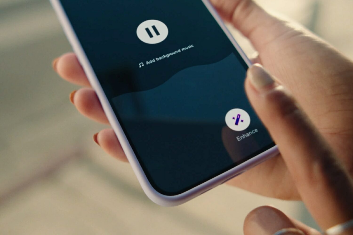 A closeup showing a woman holding an iPhone in her hand while touching the Enhance button in Spotify's Anchor app