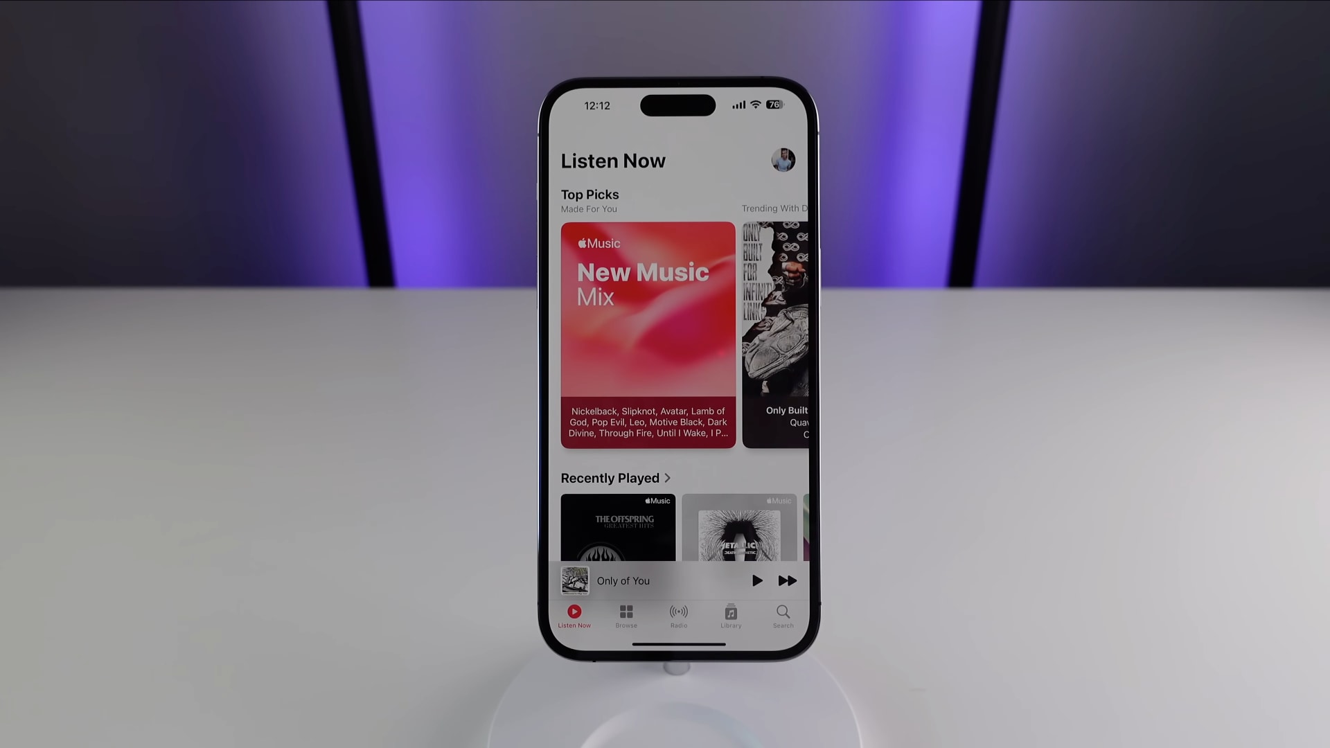 iPhone standing upright on a white table, showcasing the My Music Mix playlist in the Music app