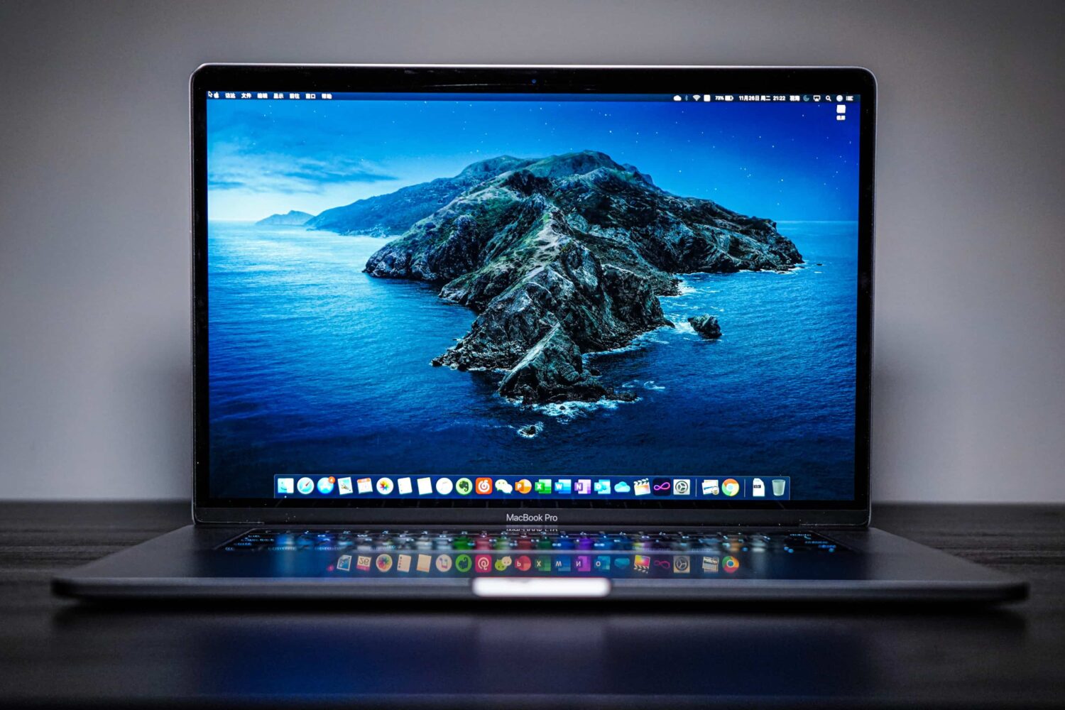 15-inch MacBook Pro with its lid open, laid on a black wooden desk
