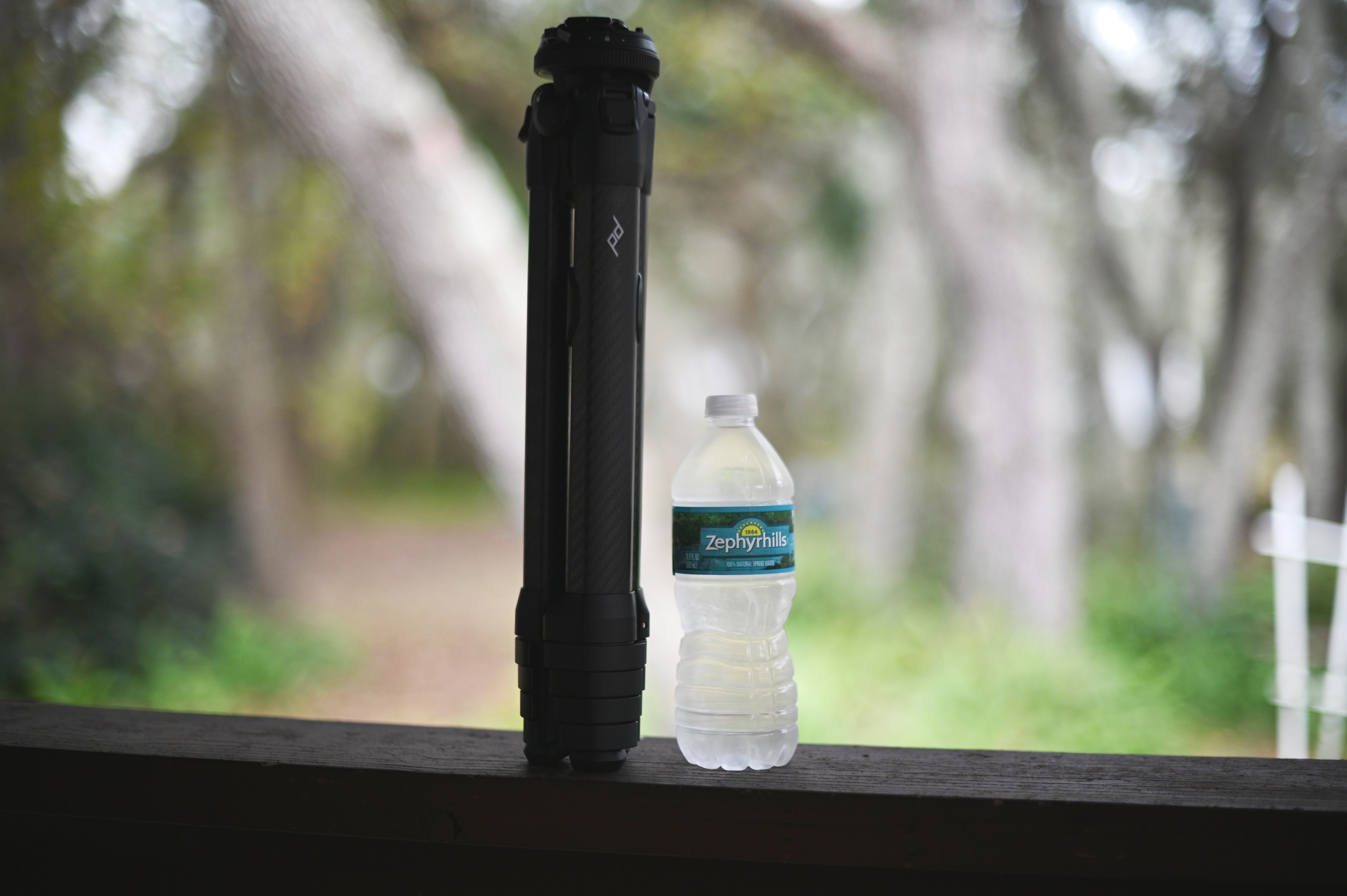 Peak Design travel tripod near a water bottle for comparison.