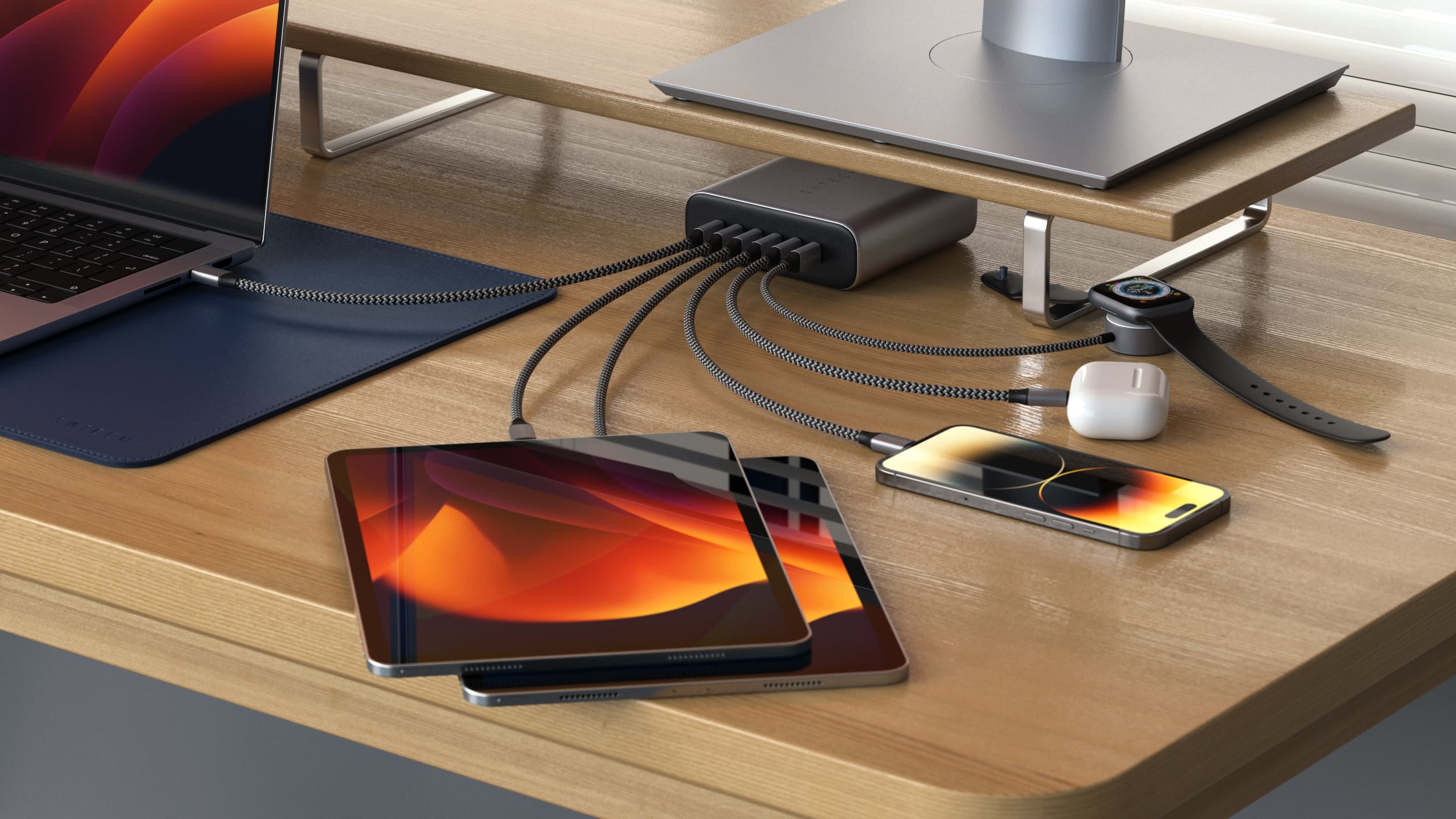 Satechi's multi-port 200W power adapter shown charging two iPads, two iPhones, a MacBook Pro, AirPods and an Apple Watch