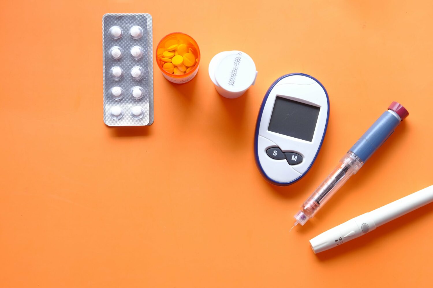 Insulin pen, diabetic measurement tools and pills set against a gradient orange backdrop