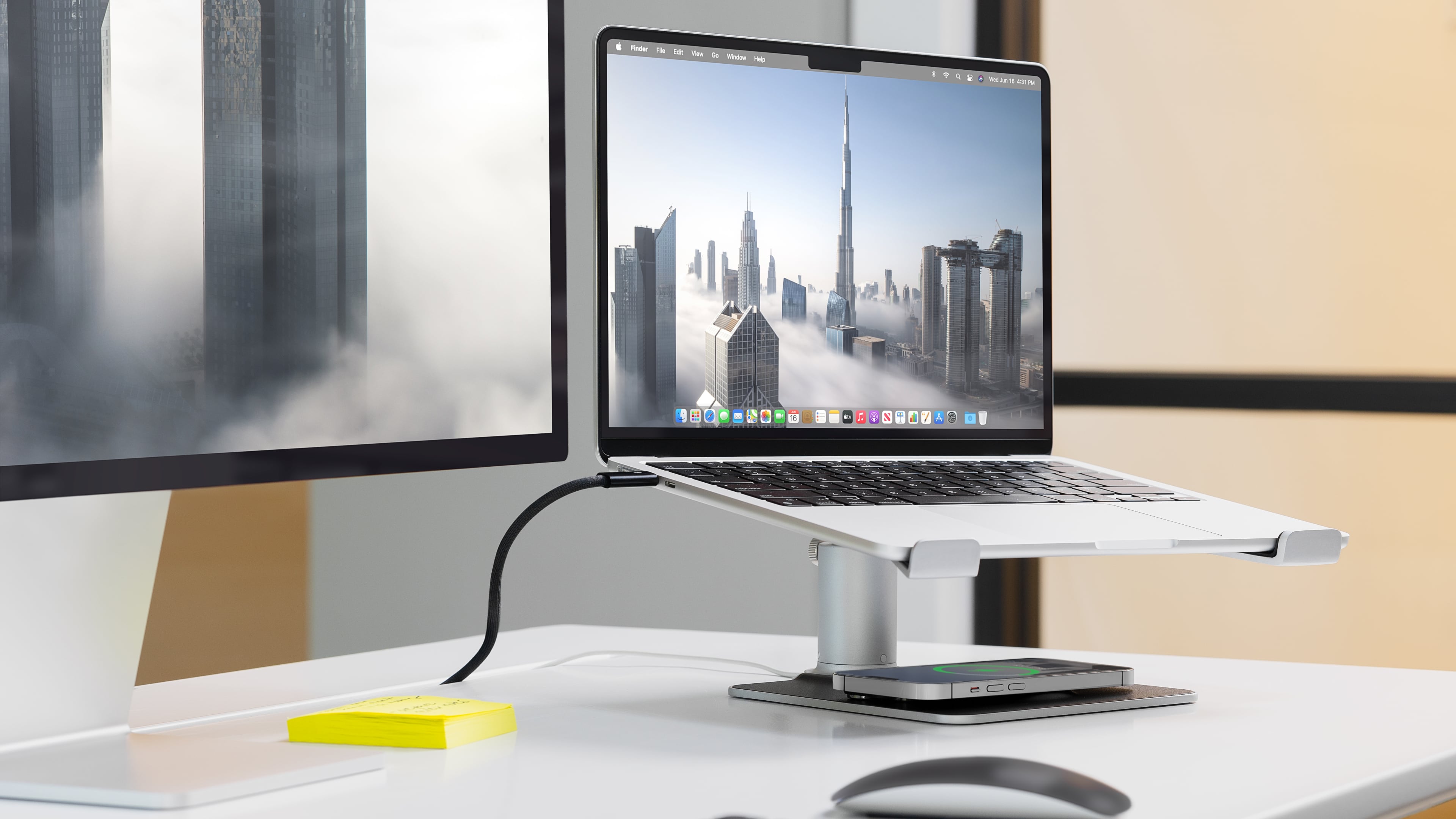 MacBook Pro on twelve South's HiRise Pro stand, with an iPhone charging on its base