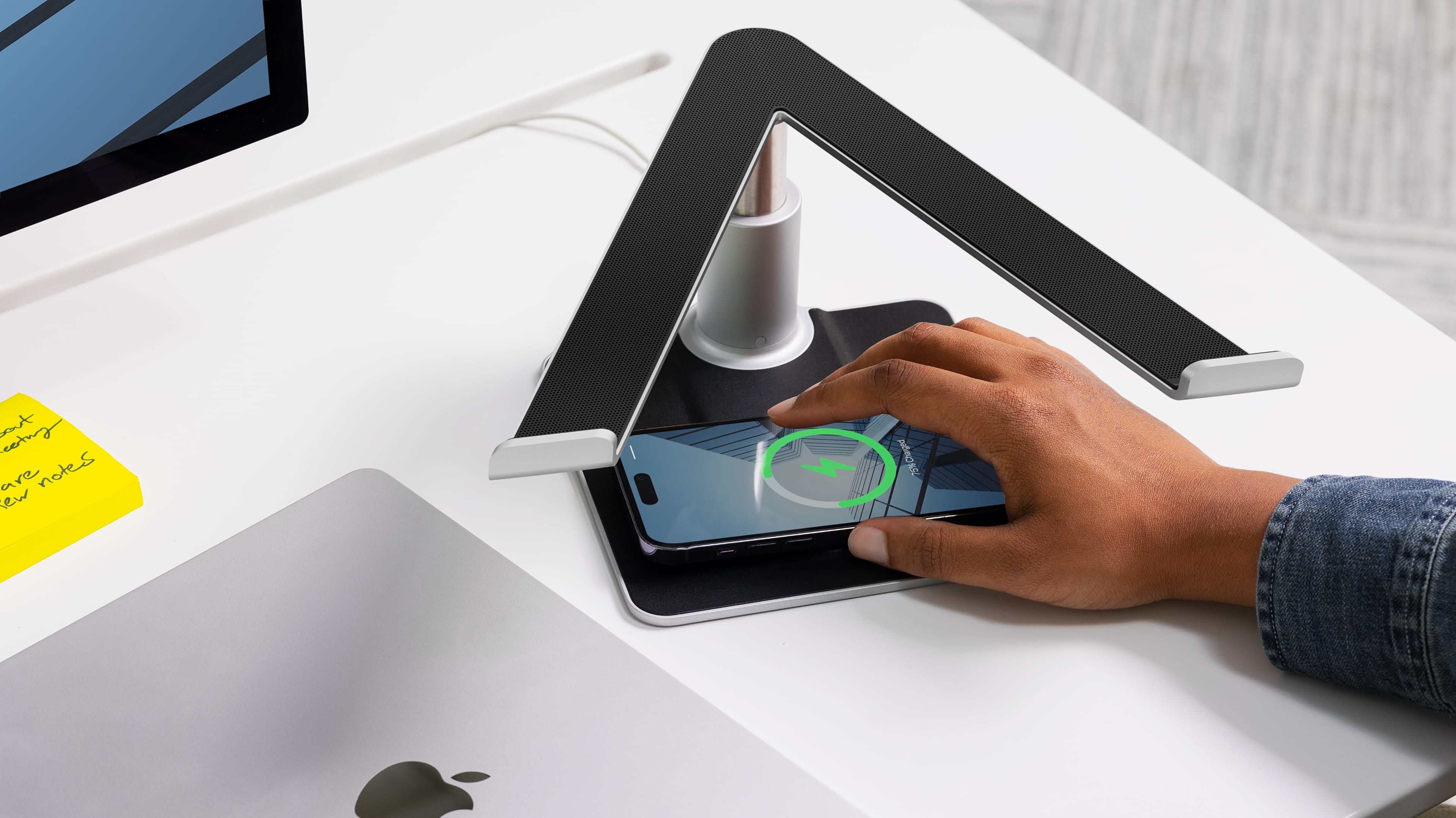Male hand dropping an iPhone on the base of Twelve South's HiRise Pro stand 