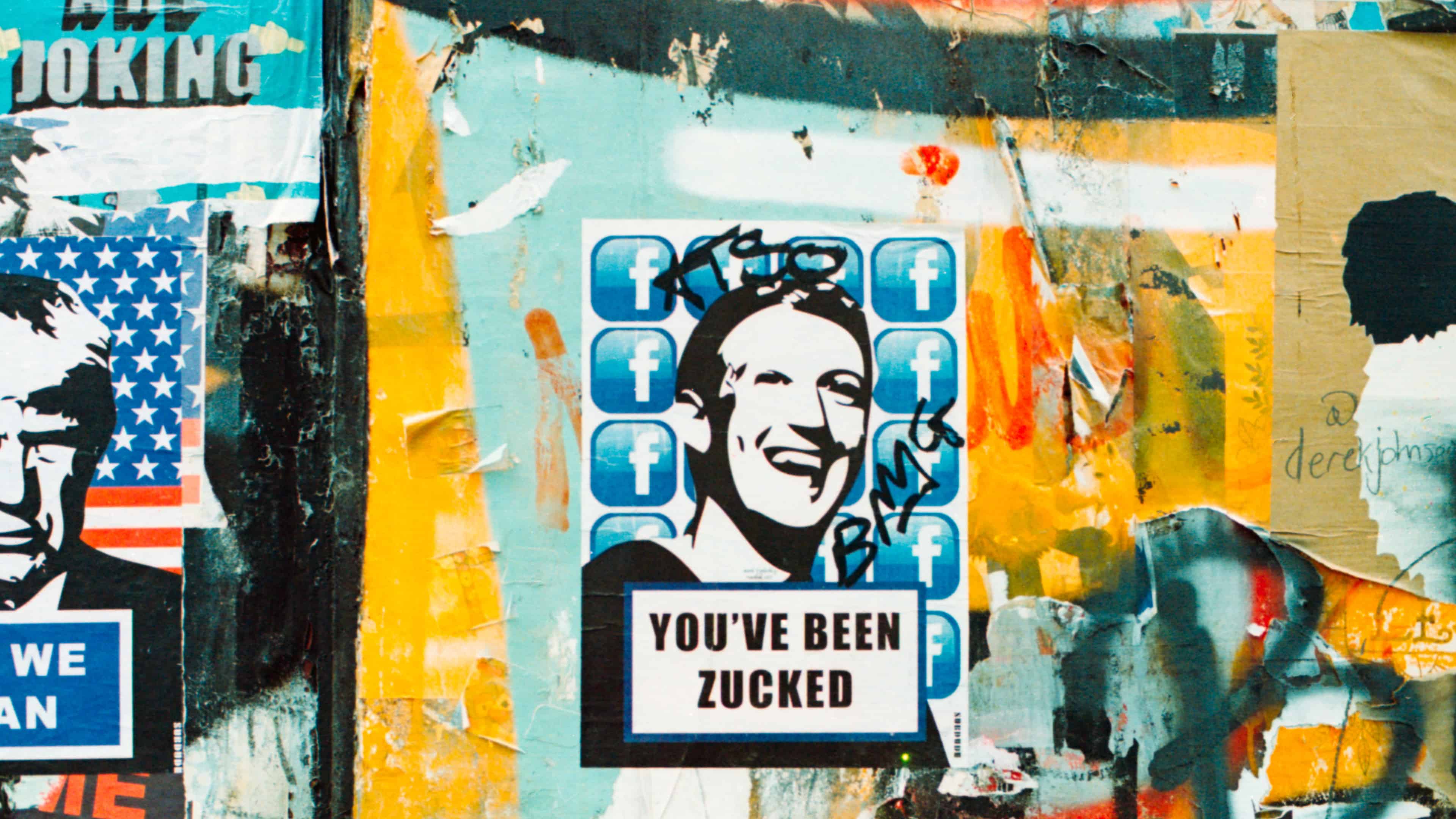 London street art showcasing a bunch of stickers on the side of a building, including one with a Mark Zuckerberg portrait and the tagline "You've been Zucked"