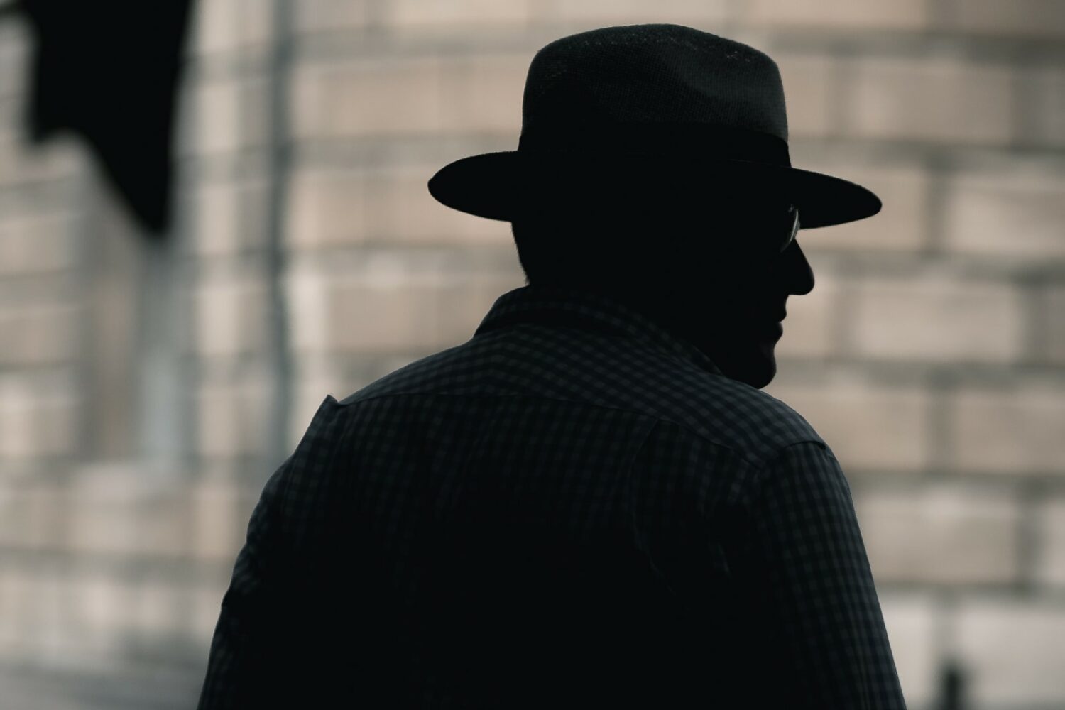 Silhouette of a detective standing on the street, set against a blurred focus background