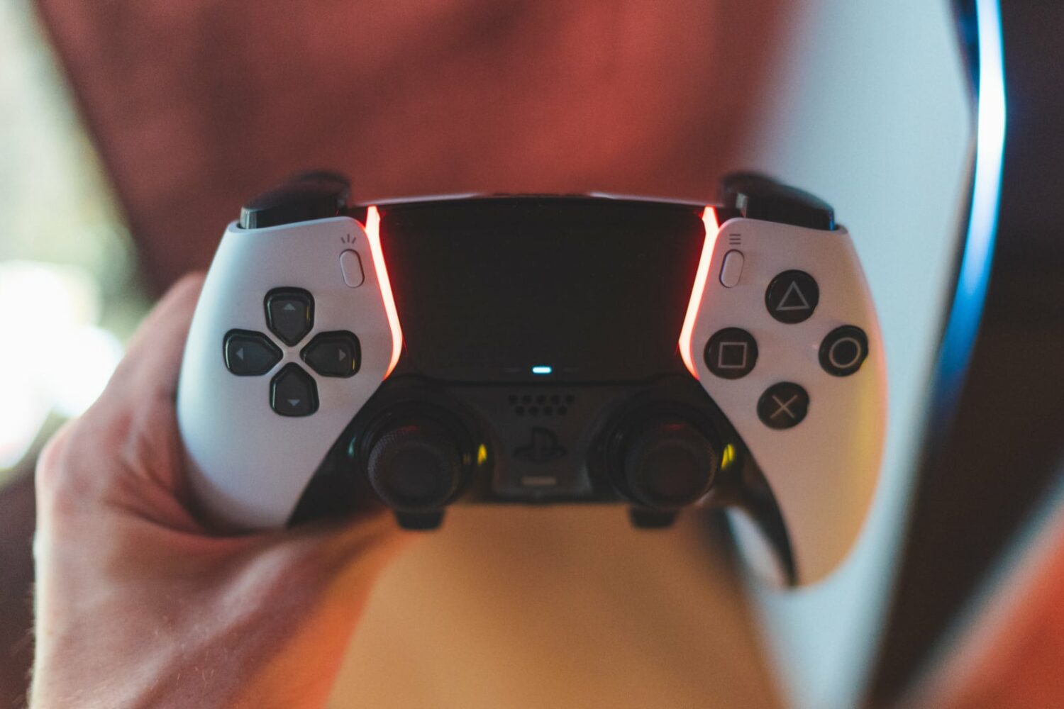 Sony's DualSense Edge controller in a person's hand, set against a blurred background