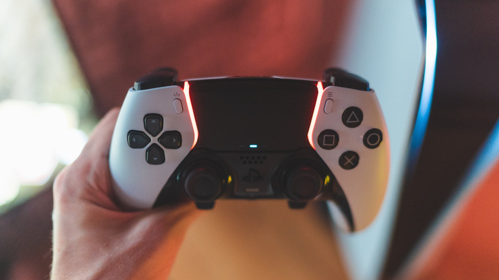 Sony's DualSense Edge controller in a person's hand, set against a blurred background 
