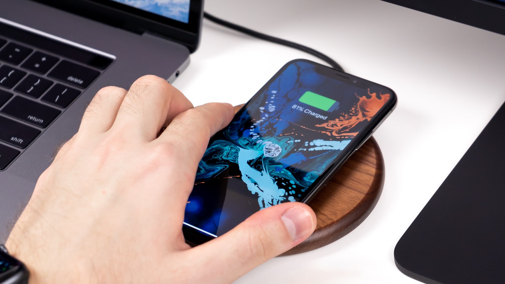 Closeup of a male hand putting an iPhone 11 on a Qi wireless charger