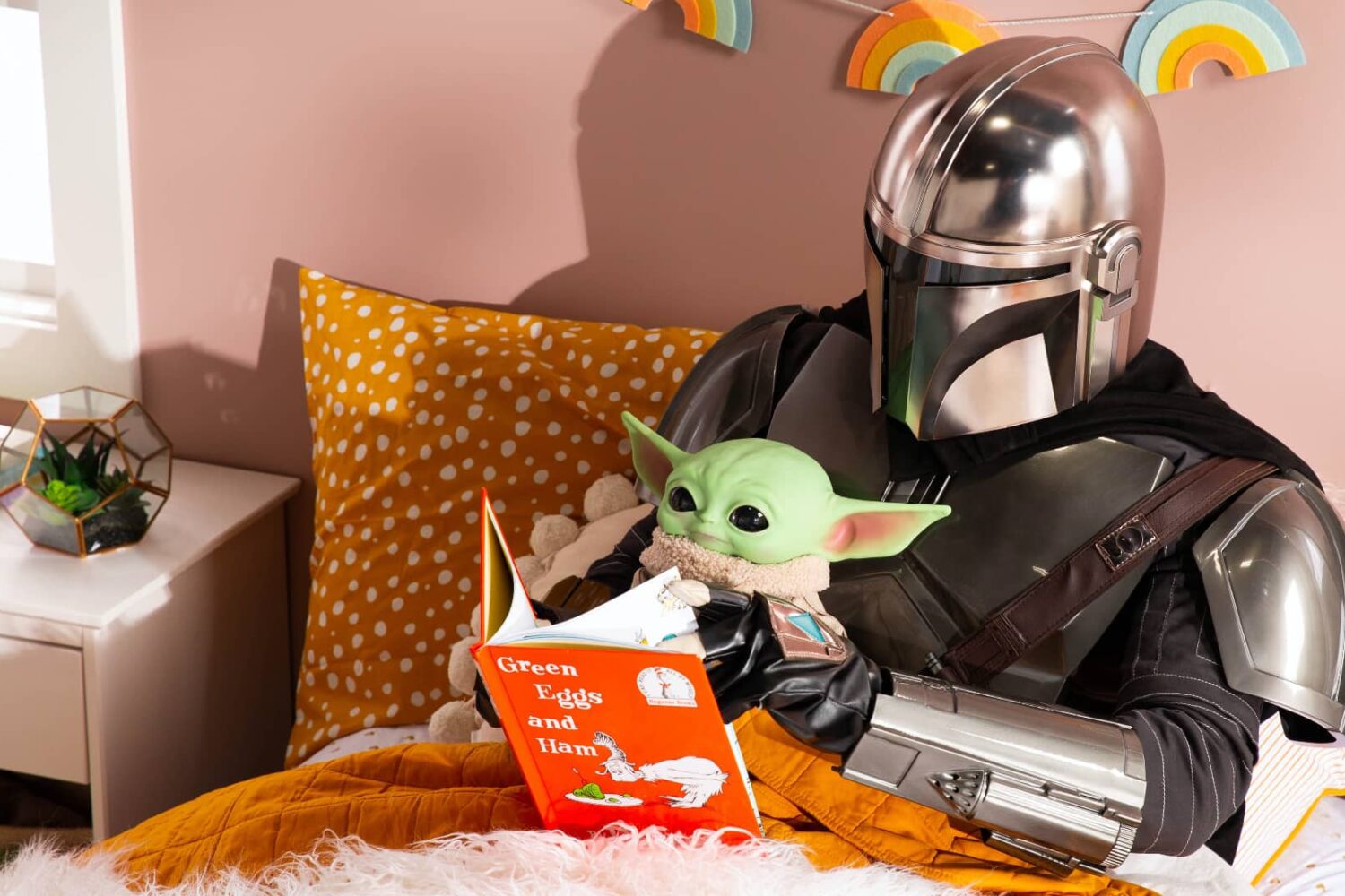 The Mandalorian and Grogu lying together in bed, reading a book