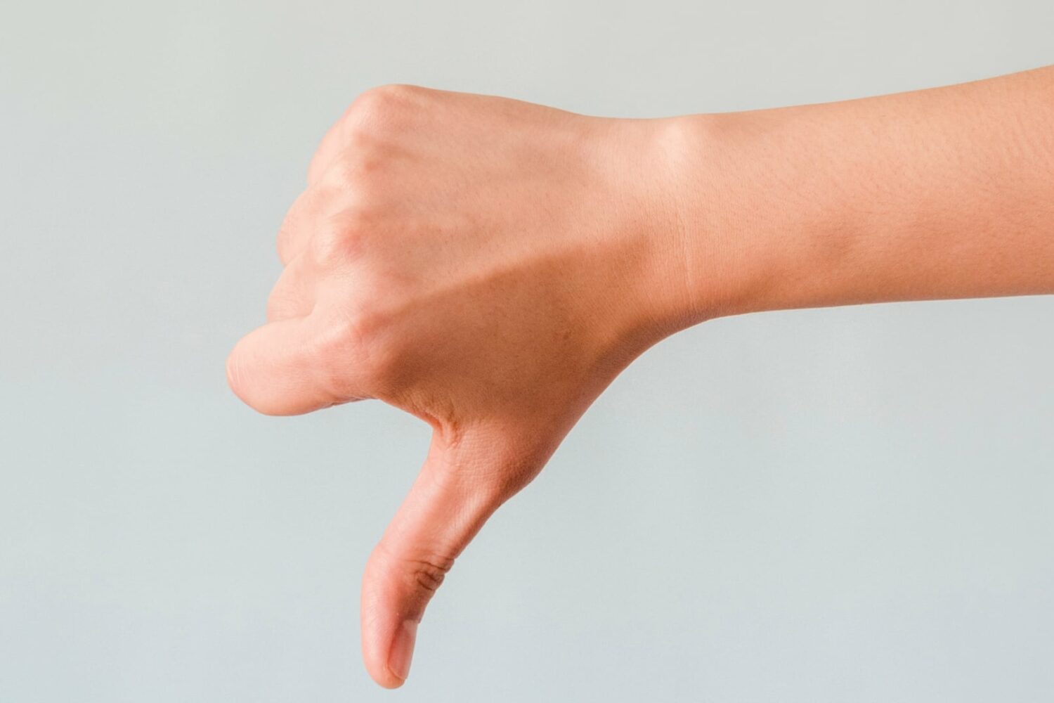 A male hand showing a thumbs-down gesture